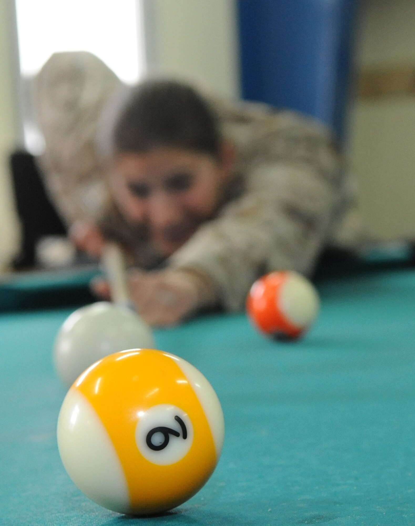 U.S. Navy Lt. Catherine Visintainer, emergency medical doctor, shoots pool at "Shooters," a recreational center at the Transit Center at Manas, Kyrgyzstan, Feb. 19, 2010. She is en route to a forward operating base in Afghanistan to augment the U.S. Marine Corps. (U.S. Air Force photo/Senior Airman Nichelle Anderson/released). 