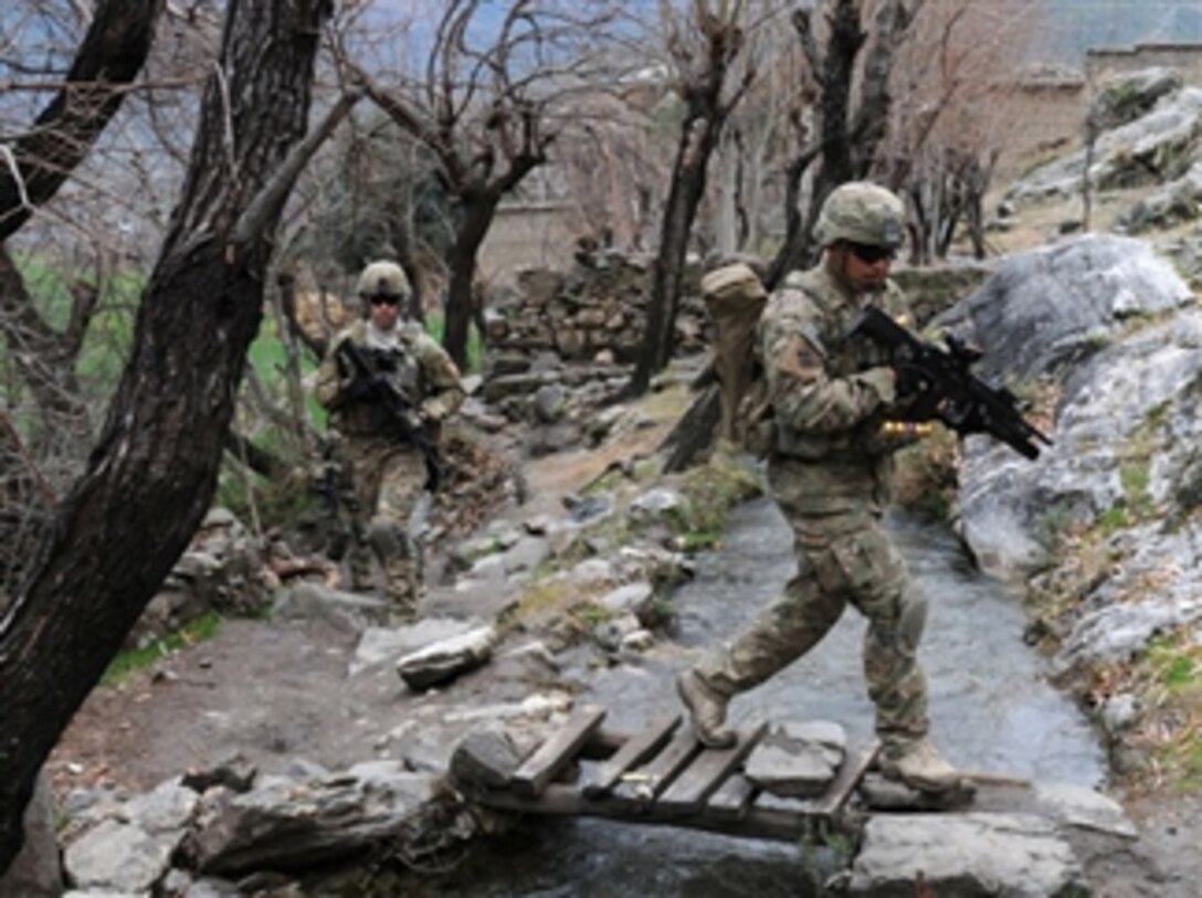 U.S. Army Spc. Jesus B. Fernandez crosses a stream during a unit visit to Angla Kala village in the Kunar province, Afghanistan, on Feb. 6, 2010.  International Security Assistance Force troops regularly meet with village elders to improve communications between residents and government officials.  Fernandez is an assistant team leader 3rd Platoon, Chosen Company, 2nd Battalion, 12th Infantry Regiment, 4th Brigade Combat Team, 4th Infantry Division.  