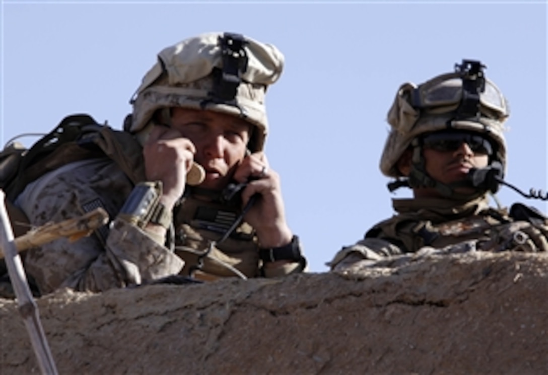 U.S. Marine Corps Capt. Stephan P. Karabin, commander of Charlie Company, 1st Battalion, 3rd Marine Regiment, gives directions to units on two different radios from a rooftop during a firefight at Five Points, Afghanistan, on Feb. 9, 2010.  The intersection links the northern area of the insurgent stronghold of Marja with the rest of Helmand province.  