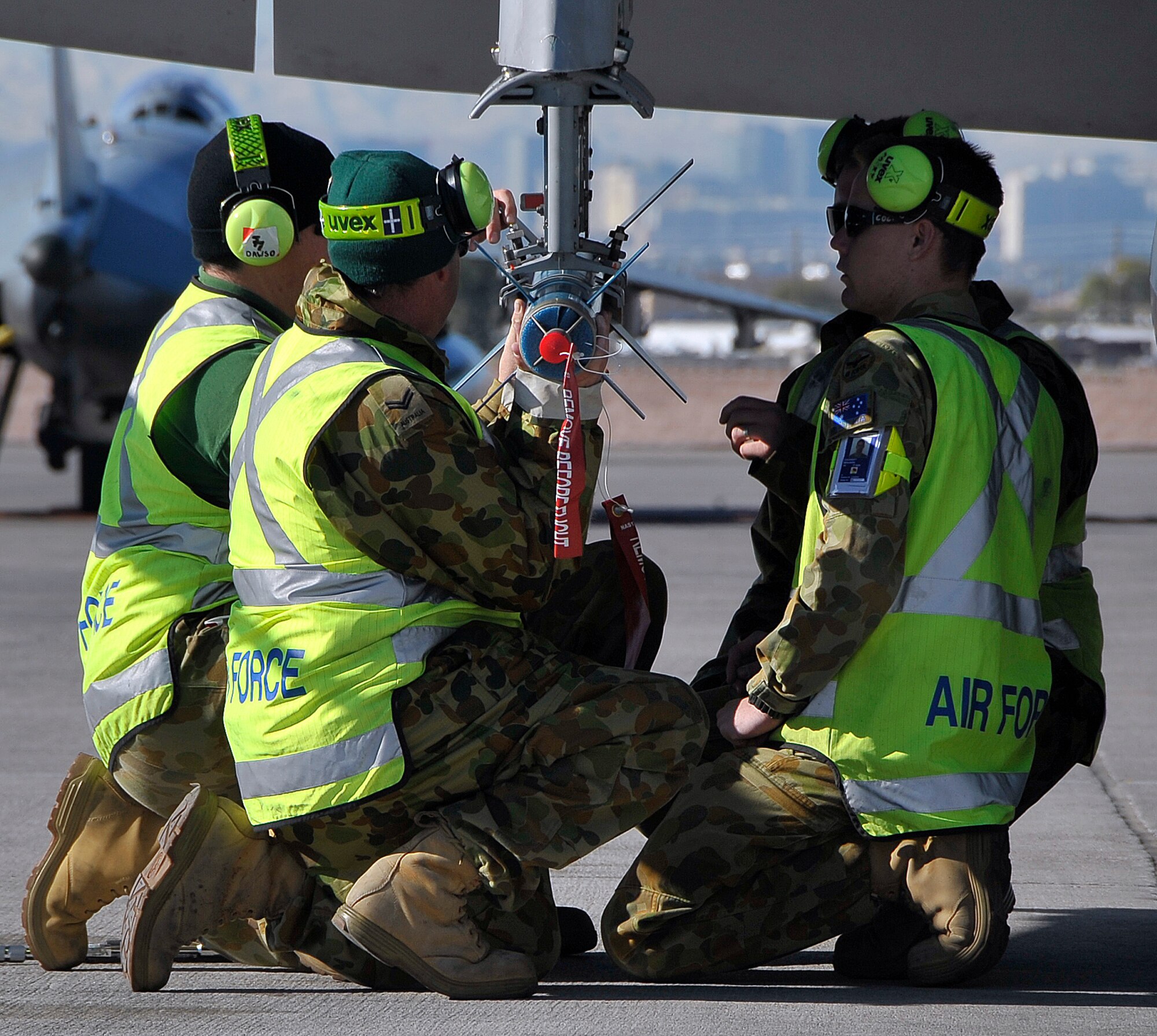 NELLIS AIR FORCE BASE, Nev. -- Members of the 77th Squadron, Royal Australian Air Force, load a laser-guided training round onto a F/A-18 Hornet during Red Flag 10-3 Feb. 23. These RAAF members traveled 22 hours from RAAF Base Williamtown, Australia, to participate in the combined forces exercise. (U.S. Air Force photo by Tech. Sgt. Chris Flahive)