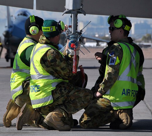 NELLIS AIR FORCE BASE, Nev. -- Members of the 77th Squadron, Royal Australian Air Force, load a laser-guided training round onto a F/A-18 Hornet during Red Flag 10-3 Feb. 23. These RAAF members traveled 22 hours from RAAF Base Williamtown, Australia, to participate in the combined forces exercise. (U.S. Air Force photo by Tech. Sgt. Chris Flahive)