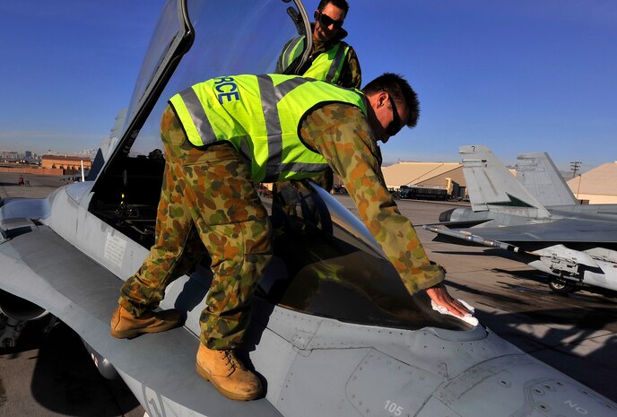 NELLIS AIR FORCE BASE, Nev. -- Leading Air Craftsman David Bennett, helped by Cpl. Dan Mahoney, both from the 77th Squadron, Royal Australian Air Force, wipes down the canopy of an F/A-18 Hornet during Red Flag 10-3 Feb. 23. Craftsman Bennet and Corporal Mahoney hail from RAAF Base Williamtown near Newcastle, Australia, and are participating in their first Red Flag exercise. (U.S. Air Force photo by Tech. Sgt. Chris Flahive)