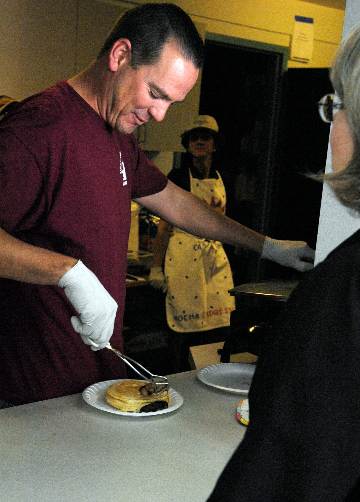 VANDENBERG AIR FORCE BASE, Calif. -- Bringing on the pork, Master Sgt. James Pilkenton, first sergeant for the 533rd Training Squadron, places sausages on a plate during the First Sergeants' Pancake Breakfast hosted by the Airman and Family Readiness Center here Monday, Feb. 22, 2010. The breakfast was used to kick off the Military Saves Week, which urges Airmen to join classes that teach saving and investing. (U.S. Air Force photo/Airman 1st Class Lael Huss)
