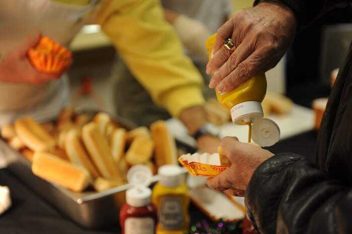 A hungry attendee adds mustard to a hotdog at the Second Annual Force Support Squadron Food Show here Feb. 18. (U.S. Air Force photo/Senior Airman Daniel Owen)