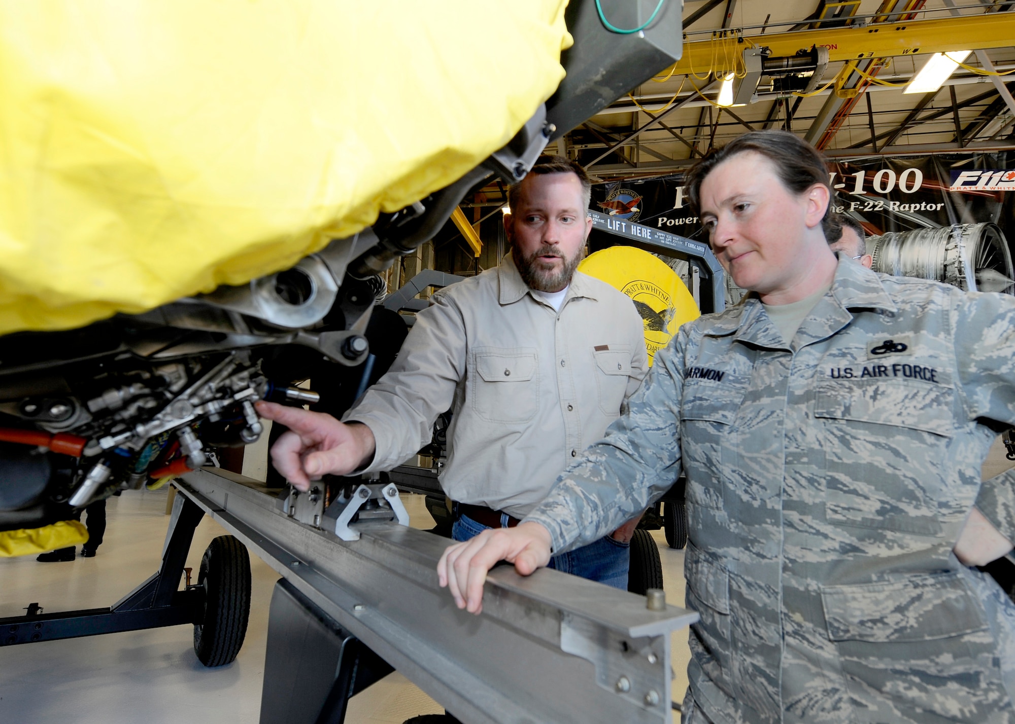 HOLLOMAN AIR FORCE BASE, N.M. -- Eric Ogren, F-119 site manager for Pratt and Whitney, shows Chief Master Sgt. Kathleen Harmon, 49th Maintenance Squadron superintendent, components of an F-119 engine during the opening of the newly renovated engine shop, Feb. 12. The building helps Airmen and Pratt and Whitney maintain the F-119 engines for the F-22 Raptor. (U.S. Air Force photo by Airman 1st Class Veronica Stamps)