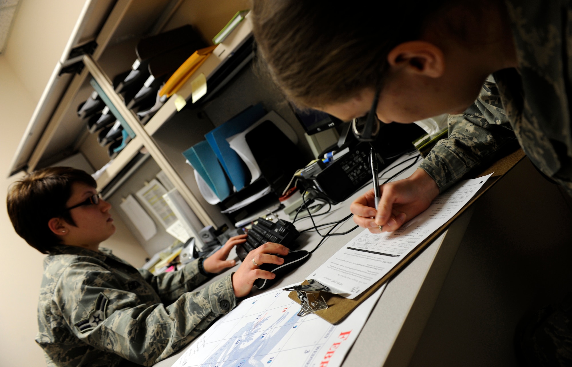 Airman 1st Class Sarah Gibson updates records in the Preventive Health Assessment and Individual Medical Readiness system as Airman Alyssa Carlson fills out a pre-deployment health assessment Feb. 17, 2010, Eielson Air Force Base, Alaska. Public Health is the first stop in medical group for deployment out processing. Airmen Gibson and Carlson are 354 Medical Group public health technicians. (U.S. Air Force photo/Airman 1st Class Willard E. Grande II)