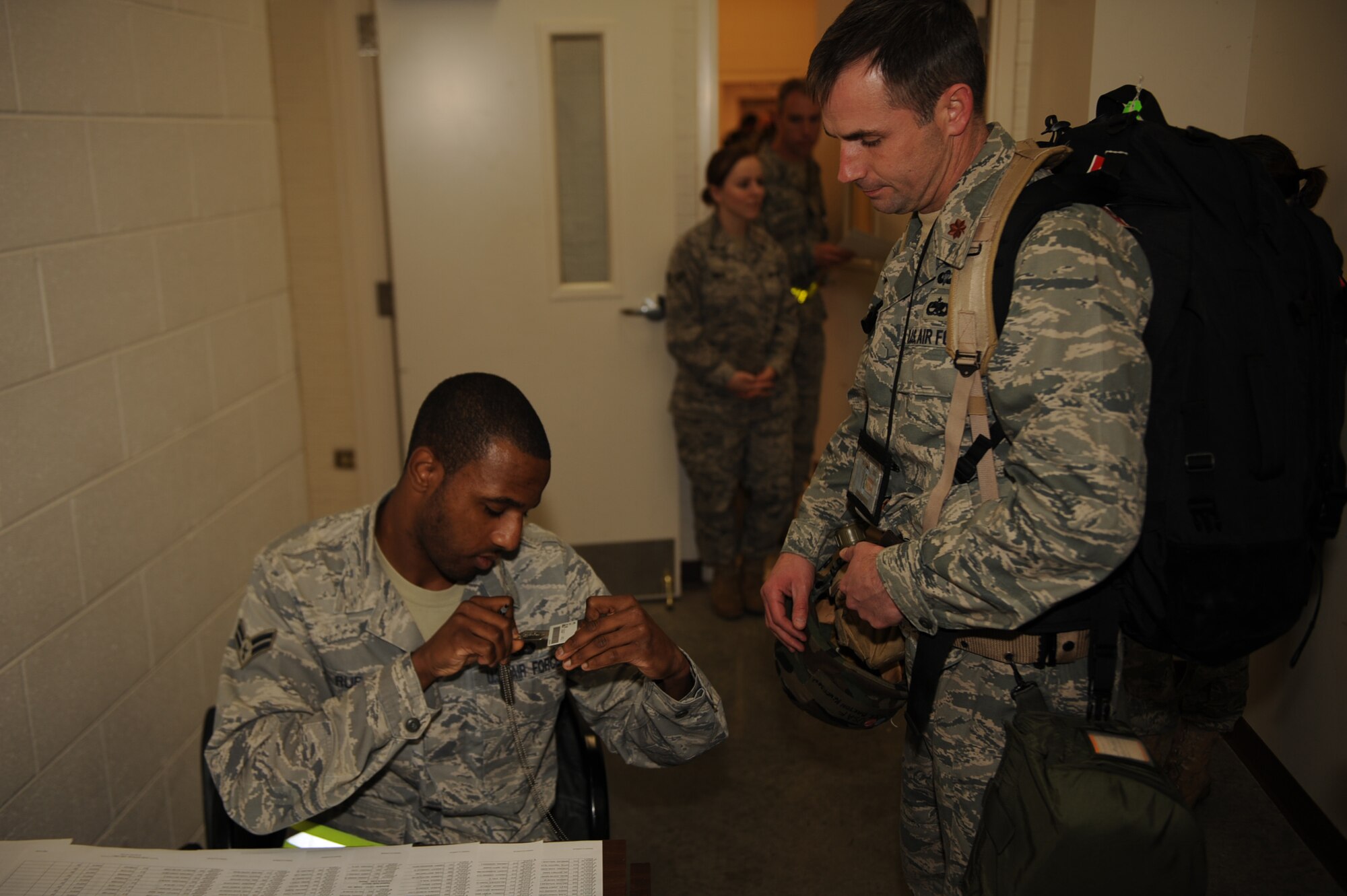 Airman 1st Class Trymond Rubin, 4th Force Support Squadron fitness and sports specialist, checks Maj. Barton Kenerson, 4th Component Maintenance Squadron commander, ID card and dog tags during the Phase I exercise on Seymour Johnson Air Force Base, N.C., Feb. 23, 2010. Rubin checks ID's and dog tags simultaneously to ensure the information on both items match. Rubin is from Sumter, S.C., and Kenerson is from Tennessee.(U.S. Air Force photo/Senior Airman Ciara Wymbs) 