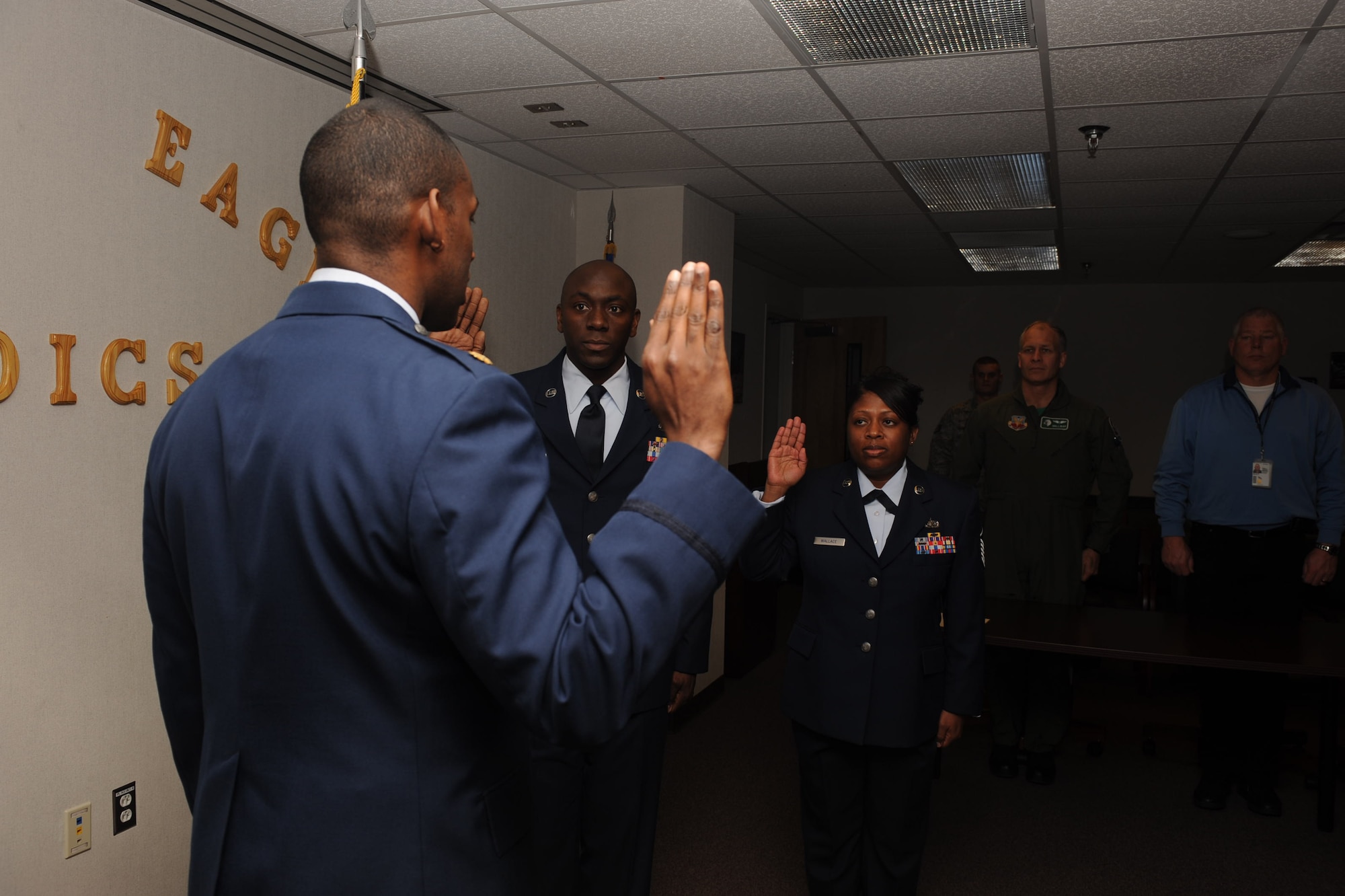 Maj. Dolphis Hall, 4th Medical Group resource management flight office commander and group practice manager, reenlists Master Sgts. Shaffinie Wallace, 4th Medical Group first sergeant, and Ataya Wallace, 4th Fighter Wing command section superintendent, in the Thomas Koritz Clinic training room, Feb. 19, 2010. The Wallace's  have a combined 34-years of Air Force service and reenlisted to accept orders to Misawa Air Base, Japan.  Shaffinie is from Butler, Ala. and Ataya hails from Madisonville, Ky. (U.S. Air Force photo/Senior Airman Whitney Lambert)