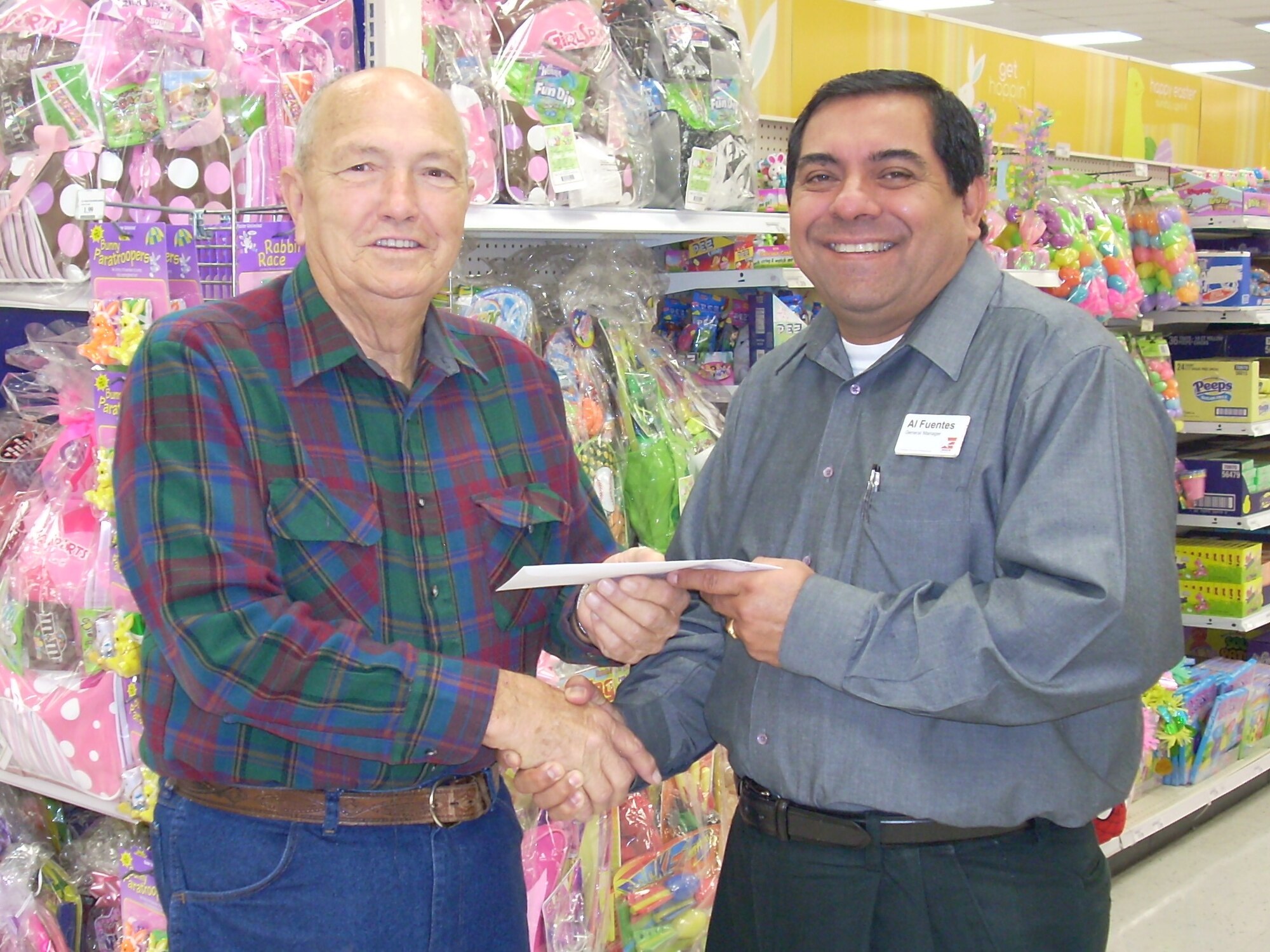 Billy Griffith accepts $5,000 in gift cards from Al Fuentes, Tyndall AAFES Base Exchange general manager, Feb. 23. Mr. Griffith entered the Spring into Summer sweepstakes, an AAFES-wide event.  He said he has entered sweepstakes for years and this is the first time he has won anything. Mr. Griffith plans to purchase new tires for his vehicle and a dishwasher for his wife. (U.S. Air Force courtesy photo)