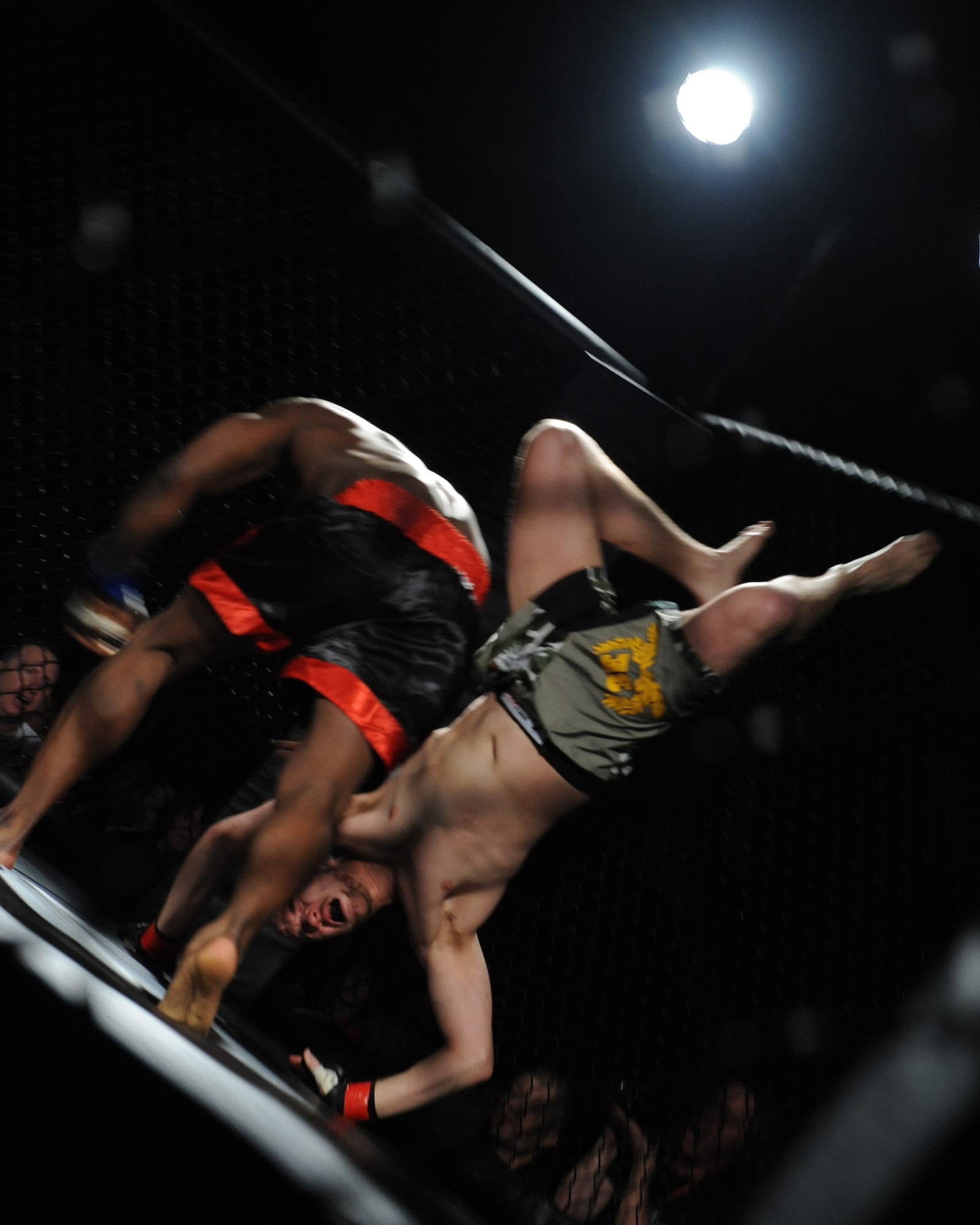 Bradley "Big Daddy" Desir flips Adam Dehart during a Mixed Martial Arts cage fight title match at Seymour Johnson Air Force Base, N.C., Feb. 19, 2010. Desir overtook Dehart causing him to tap out in 1:59 of the fifth round, earning him the middleweight North Carolina International Sport Combat Federation and Fight Lab promotions titles. (U.S. Air Force photo/Senior Airman Whitney Lambert)