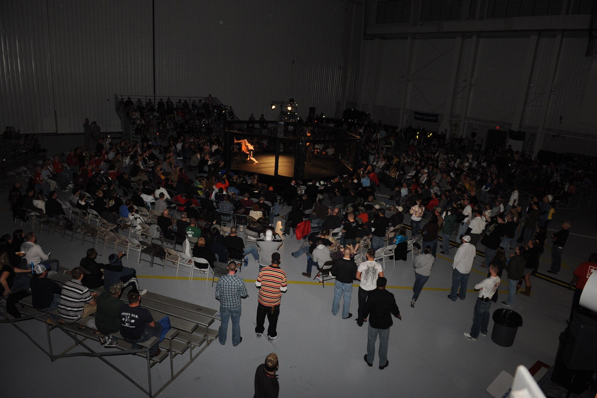 Members of the Seymour Johnson Air Force Base community watch the first Mixed Marital Arts cage fight of the night between Rusty Haun and Austin Hiatt on Seymour Johnson Air Force Base, N.C., Feb. 19, 2010. Haun won the match with an arm bar submission in 2:59 of the first round. (U.S. Air Force photo/Senior Airman Whitney Lambert)