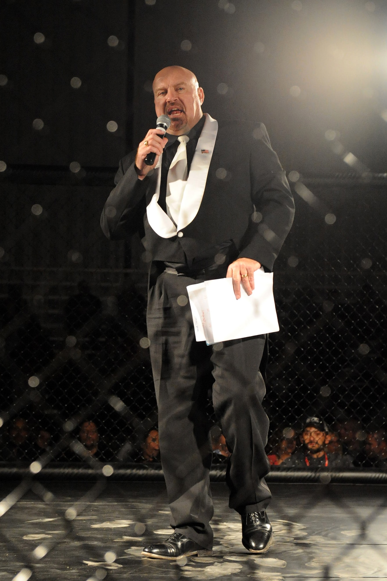Bruce Foster, ring announcer, introduces the next set of fighters during the first Mixed Martial Arts cage fight on Seymour Johnson Air Force Base, N.C., Feb. 19, 2010. Foster introduced 20 amateur fighters throughout the night providing a brief introduction for each including their name, weight, favorite fight style and the MMA company they represented. (U.S. Air Force photo/Senior Airman Whitney Lambert)