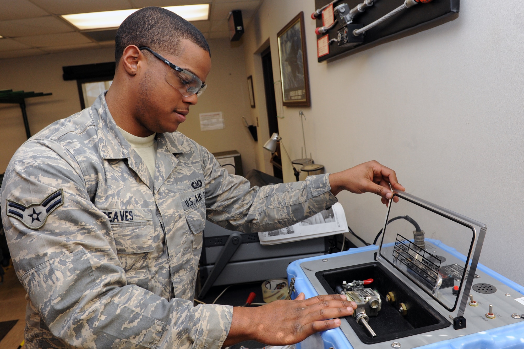 Airman 1st Class Daniel Reaves, a 19th Operations Support Squadron aircrew flight equipment apprentice, uses a Scot Tester to quality control check a Scot Release, used to deploy a parachute automatically between 15,000 and 13,000 feet in case of emergency.  (U.S. Air Force photo by Senior Airman Ethan Morgan)
