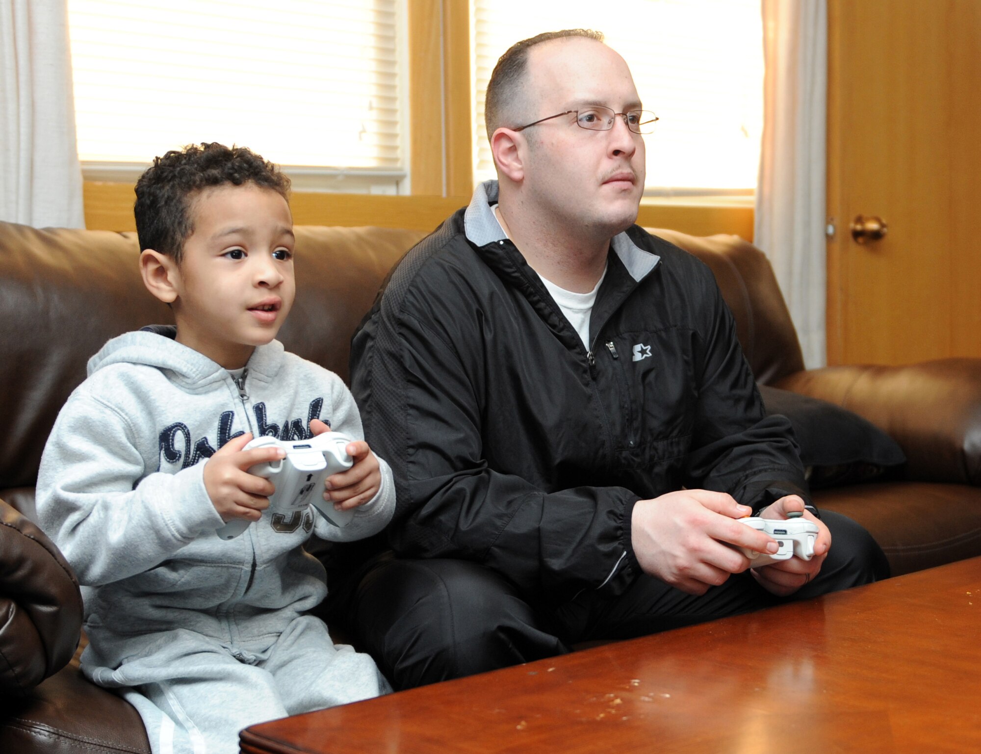 MOUNTAIN HOME AIR FORCE BASE, Idaho --  Staff Sgt. Abner Borrero, 366th Fighter Wing chaplain's assistant, and his son Javier play Xbox during a pig roast held by Liberty Chapel Feb. 19. The pig roast was held to enhance moral for the Airmen living in the dorms and included free food, a live band, karaoke and an Xbox tournament. (U.S. Air Force photo by Airman 1st Class Debbie Lockhart)