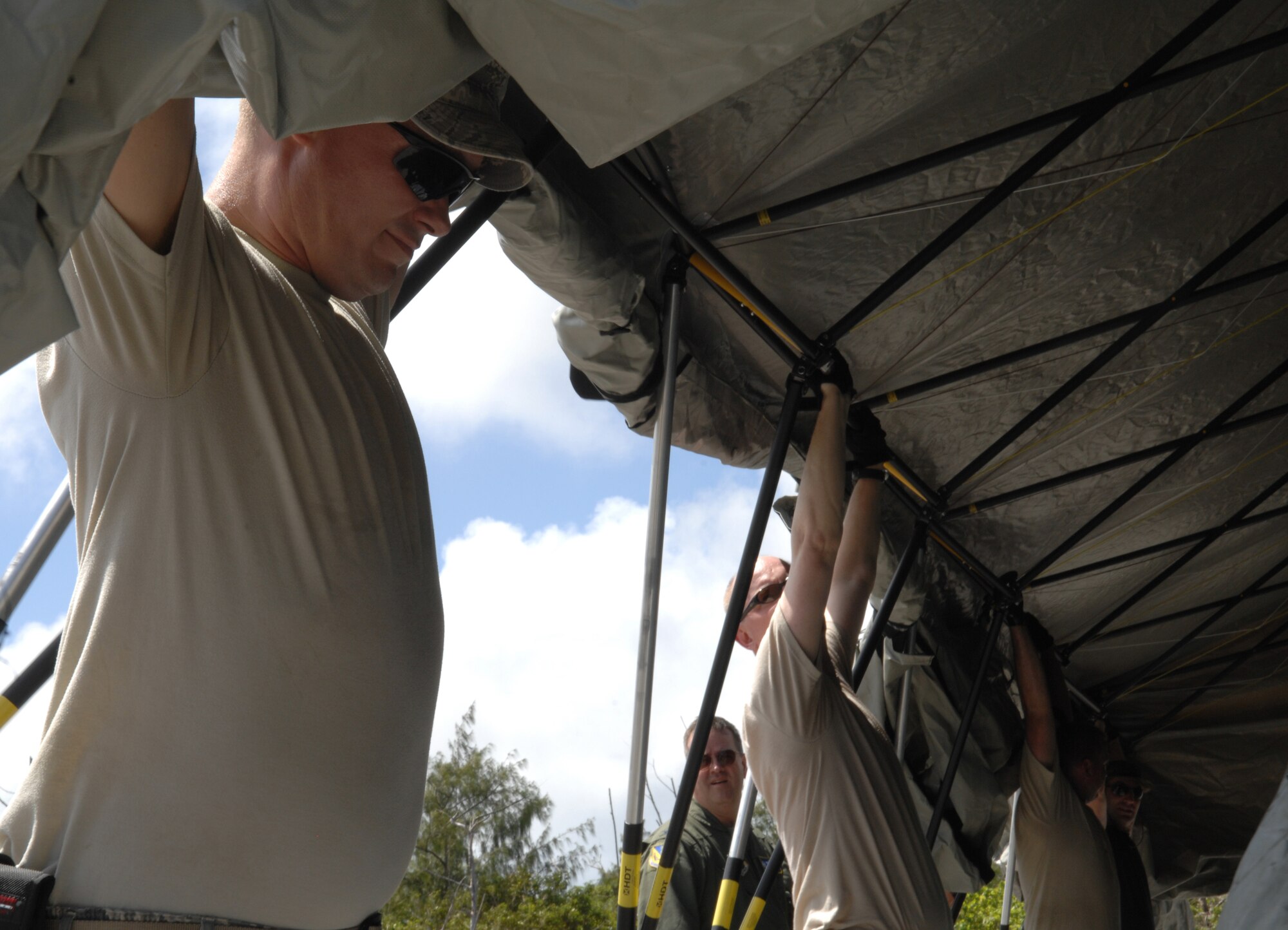 Members of the 36th Contingency Response Group at Andersen Air Force Base, Guam, and aircrews from the 374th Operations Group from Yokota Air Base, Japan, construct a shelter Feb. 17, 2010, at Northwest Field, Guam. The two units participated in a mock deployment to Northwest Field to rehearse time-critical actions for disaster relief operations. (U.S. Air Force photo/Capt. Andrew G. Hoskinson)