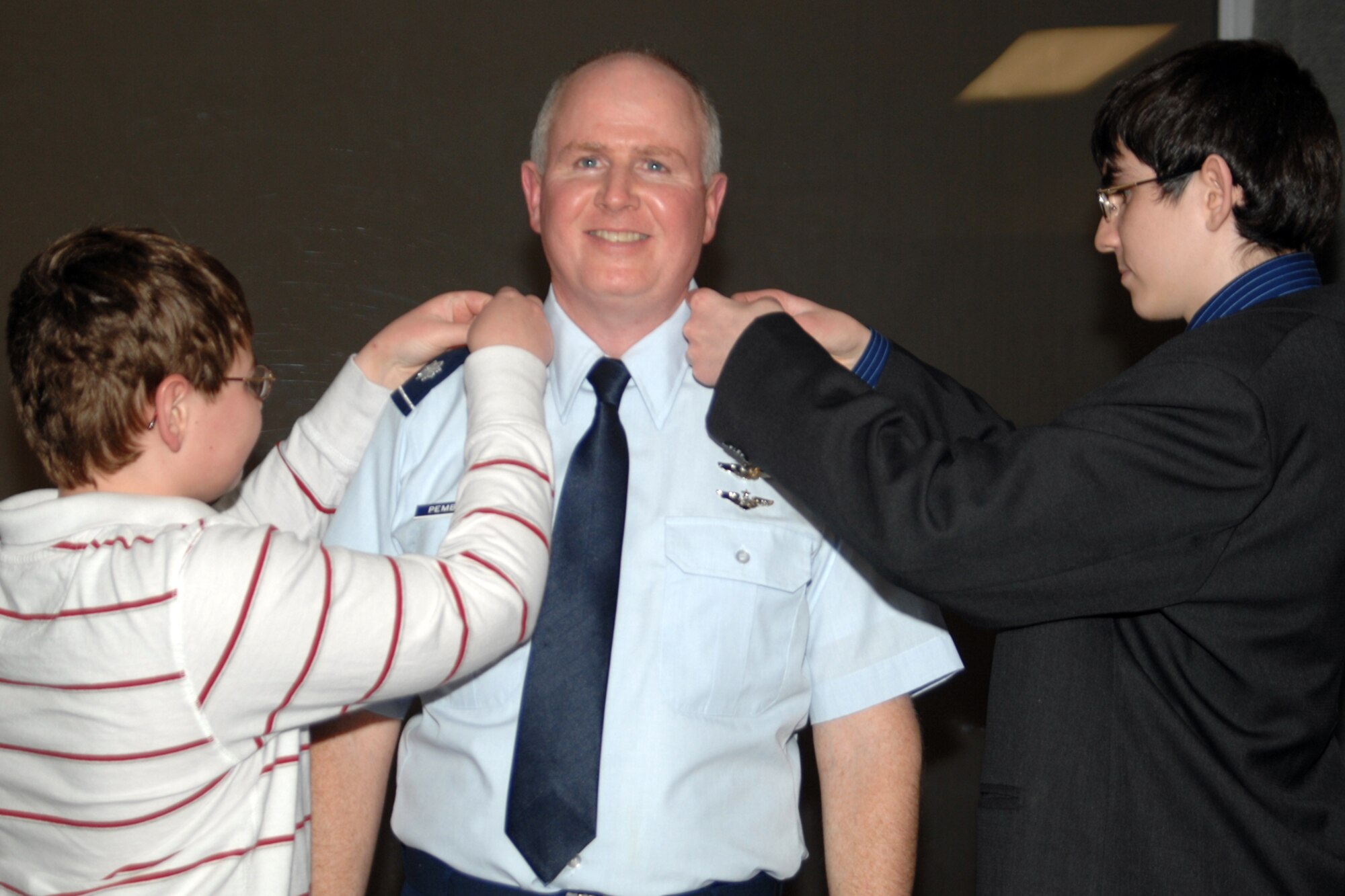GRISSOM AIR RESERVE BASE, Ind. , -- Col. Thom Pemberton,  deputy commander for the 434th Operations Group, is all smiles as his sons Ian, left,  and Andrew, replace the silver oak leaf clusters for colonel insignias on his shirt during a promotion ceremony. (U.S. Air Force photo/Tech. Sgt. Doug Hays)