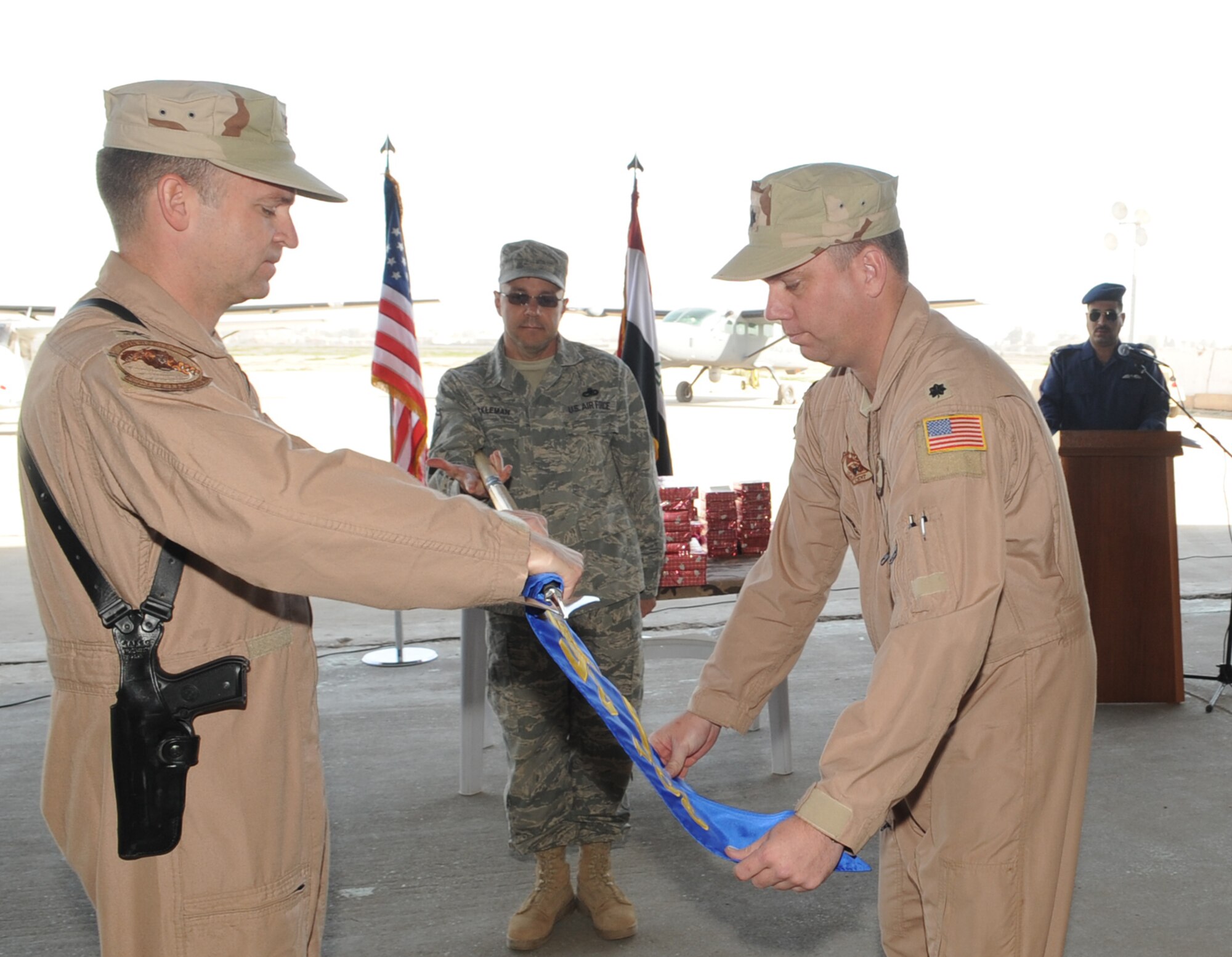 KIRKUK REGIONAL AIR BASE, Iraq – Col. Chris Pehrson, 321st Air Expeditionary Advisory Group commander, and Lt. Col. Christopher Spigelmire, 521st Air Expeditionary Advisory Squadron commander, decommission the 521 AEAS guideon Jan. 11, 2010. Their mission was to train the Iraqi air force’s Squadron 3 to fly intelligence, surveillance and reconnaissance missions, and their mission is complete. (U.S. Air Force photo by Staff Sgt. Tabitha Kuykendall) 