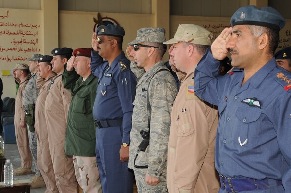 KIRKUK REGIONAL AIR BASE, Iraq – Leaders from the 521st Air Expeditionary Advisory Squadron, 321st Air Expeditionary Advisory Group and Iraqi air force Squadrons 1 and 3, salute the countries’ national anthems during the 521st Air Expeditionary Advisory Squadron decommissioning ceremony handed the reigns over to Iraqi air force Squadron 3, signifying their autonomy as they take control of their own skies. (U.S. Air Force photo/Staff Sgt. Tabitha Kuykendall) 