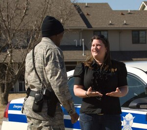LANGLEY AIR FORCE BASE, Va. -- Heather Boyer, Landings at Langley Neighborhood Watch Coordinator, speaks with Tech. Sgt. Anthony Weaver, 633d Security Forces Squadron Police Services patrol officer outside the 633 SFS dispatch center Feb. 18. Security forces are working alongside the group to combat crime in the neighborhood. (U.S. Air Force photo/Airman 1st Class Jason J. Brown)