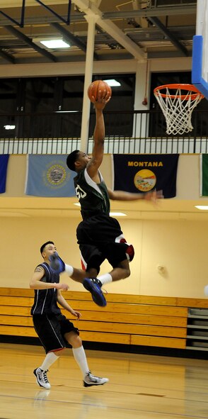 RAF MILDENHALL, England – Michael Moore, 100th Maintenance Group, glides through the air for a layup after a fast break from a turnover by the 488th Intelligence Squadron. (U.S. Air Force photo/ Staff Sgt. Jerry Fleshman)