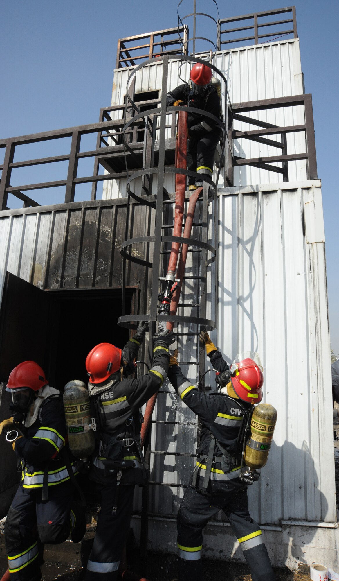 Firefighters with the Iraqi Civil Defense Training Academy pull a hose down from a building after a demonstration in Baghdad, Iraq, Feb. 17, 2010. The Iraqi Civil Defense Training Academy is currently working to establish an internationally accepted based curriculum; the future vision of the academy is to become internationally certified and become one of the premier fire training institutions in the Middle East. (U.S. Air Force photo/Master Sgt. Trish Bunting/Released)