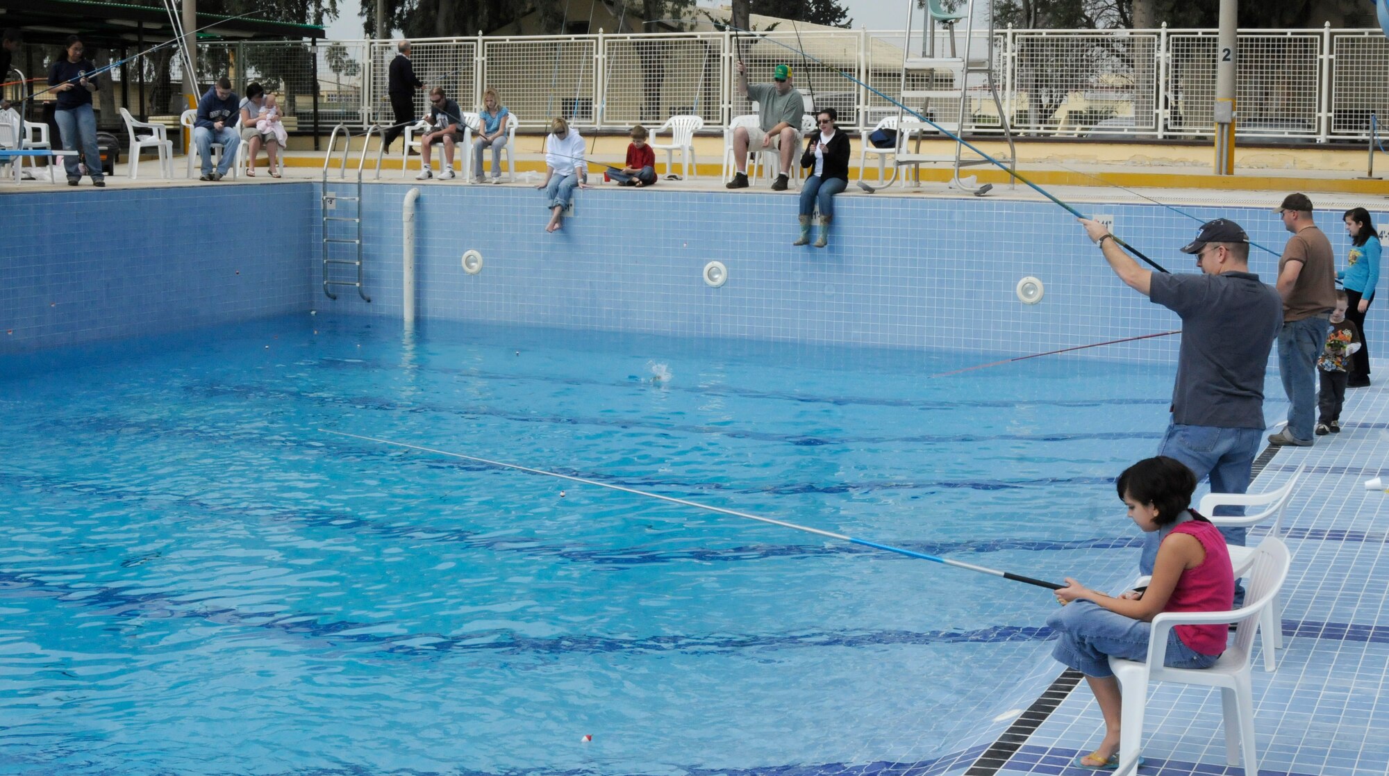 Members of Incirlik spend a day by the pool fishing Sunday, Feb. 21, 2010 during the Fishing Rodeo held by Outdoor Recreation at Incirlik Air Base, Turkey.  Outdoor Rec. staff stocked the base pool with 400 trout and allowed Incirlik members to fish over the weekend between 9 a.m. and 3 p.m. The staff also supplied the fishing poles and bait and helped clean the fish for families to take home for dinner. (U.S. Air Force photo/Airman 1st Class Amber Ashcraft)