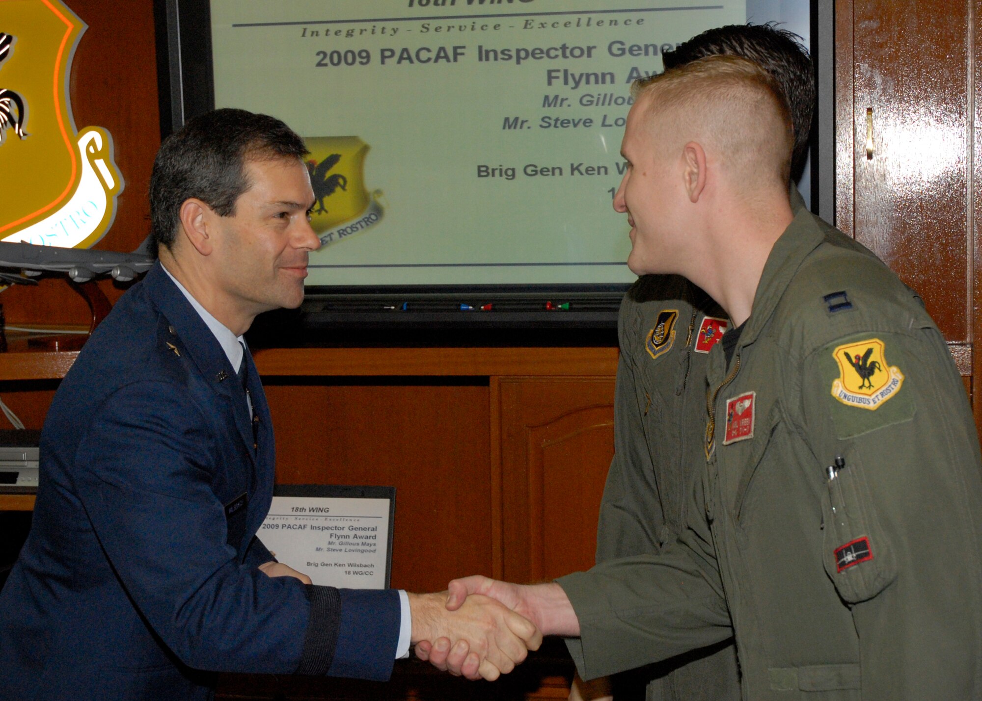 Captain Karl Kreek of the 67th Fighter Squadron receives recognition as an Air Combat Command top performer in a virtual Turkey Shoot from the 18th Wing commander, Brig. Gen. Ken Wilsbach, The Air Combat Command-sponsored Distributed Mission Operations (simulator) Turkey Shoot tested the knowledge, experience and interoperability of more than 20 “total force” aircrews in a simulated combat environment Nov. 16 - Dec. 3, 2009. (U.S. Air Force photo/Senior Airman Aaron Johnson) 