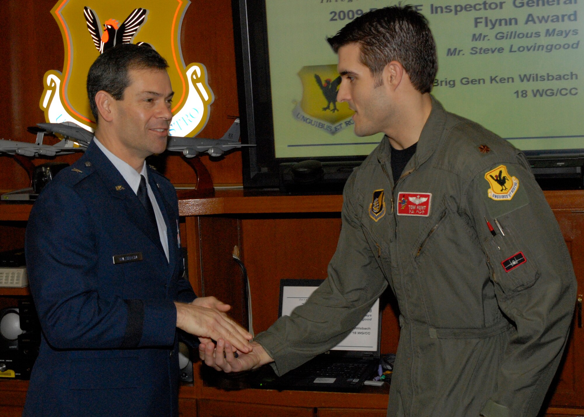 Major Tom Hunt of the 67th Fighter Squadron receives recognition as an Air Combat Command top performer in a virtual Turkey Shoot from the 18th Wing commander, Brig. Gen. Ken Wilsbach, The Air Combat Command-sponsored Distributed Mission Operations (simulator) Turkey Shoot tested the knowledge, experience and interoperability of more than 20 “total force” aircrews in a simulated combat environment Nov. 16 - Dec. 3, 2009. (U.S. Air Force photo/Senior Airman Aaron Johnson)
