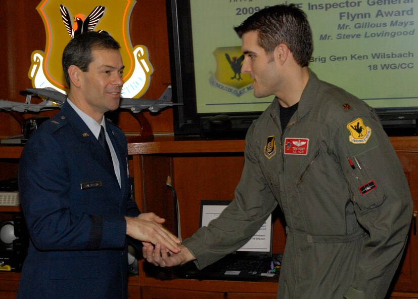 Major Tom Hunt of the 67th Fighter Squadron receives recognition as an Air Combat Command top performer in a virtual Turkey Shoot from the 18th Wing commander, Brig. Gen. Ken Wilsbach, The Air Combat Command-sponsored Distributed Mission Operations (simulator) Turkey Shoot tested the knowledge, experience and interoperability of more than 20 “total force” aircrews in a simulated combat environment Nov. 16 - Dec. 3, 2009. (U.S. Air Force photo/Senior Airman Aaron Johnson)