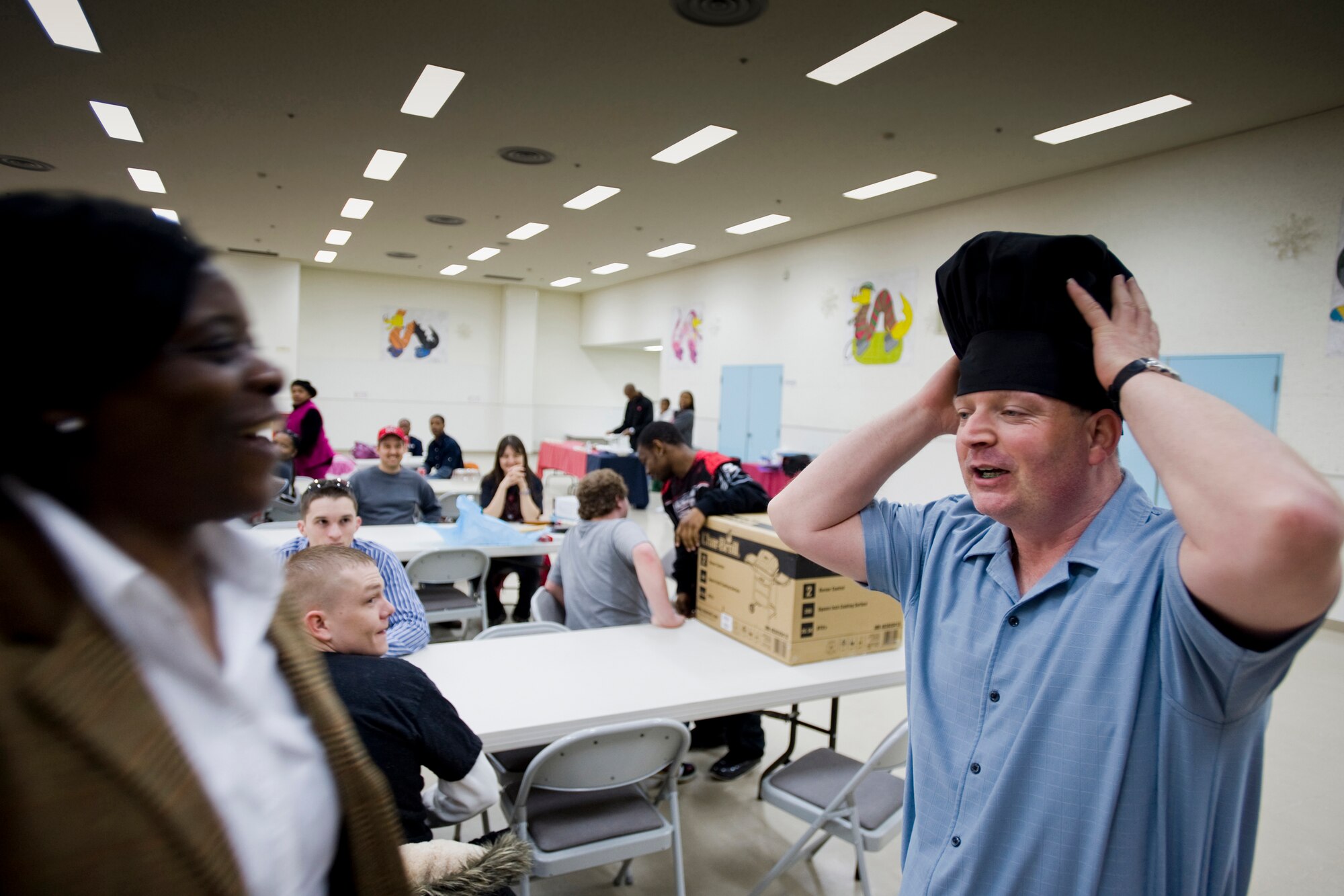 MISAWA AIR BASE, Japan -- Master Sgt. David Gilbert, 35th Maintenance Operations Squadron first sergeant, accepts a black chef hat during the Misawa Men Who Cook competition Feb. 20 at Sollars Elementary School. Sergeant Gilbert received the hat for winning the title of Top Chef during the competition with his baked beans recipe. (U.S. Air Force photo/Senior Airman Jamal D. Sutter)