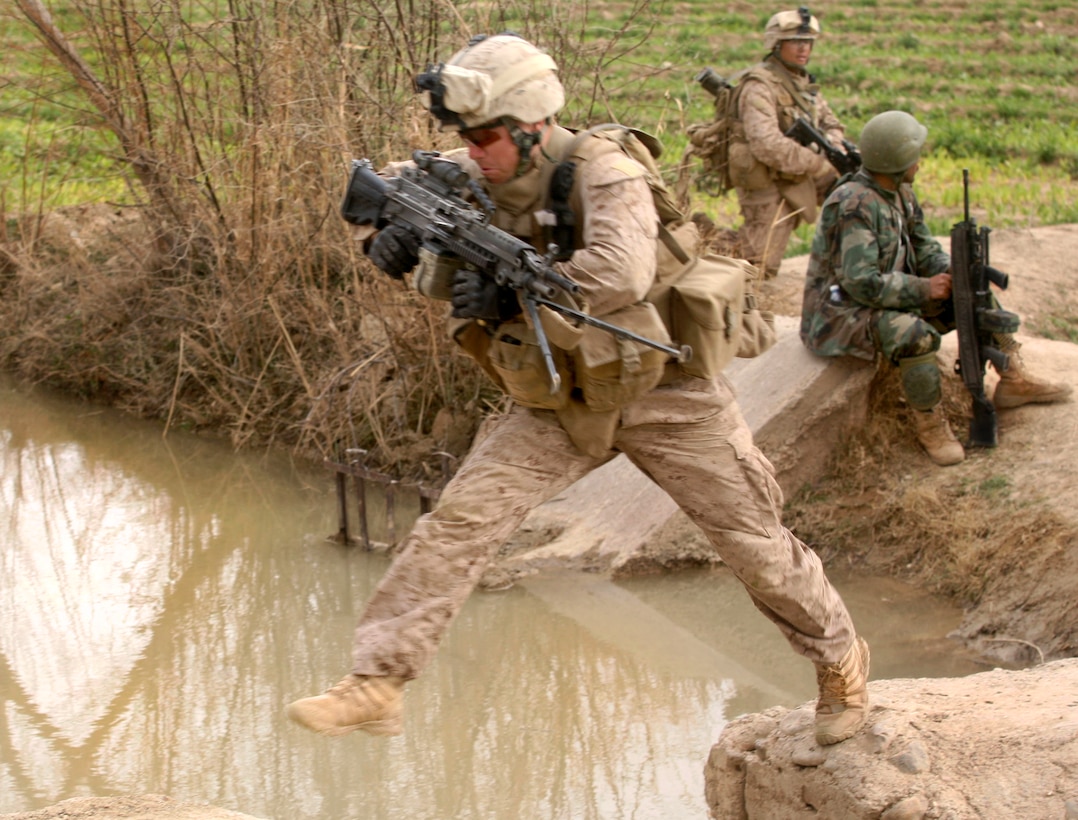 U.S. Marine Corps Lance Cpl. Ryan Hogan leaps over an irrigation canal while on a patrol in Marjah in Helmand province, Afghanistan, Feb. 21, 2010. Hogan, a rifleman, is assigned to India Company, 3rd Battalion, 6th Marine Regiment.