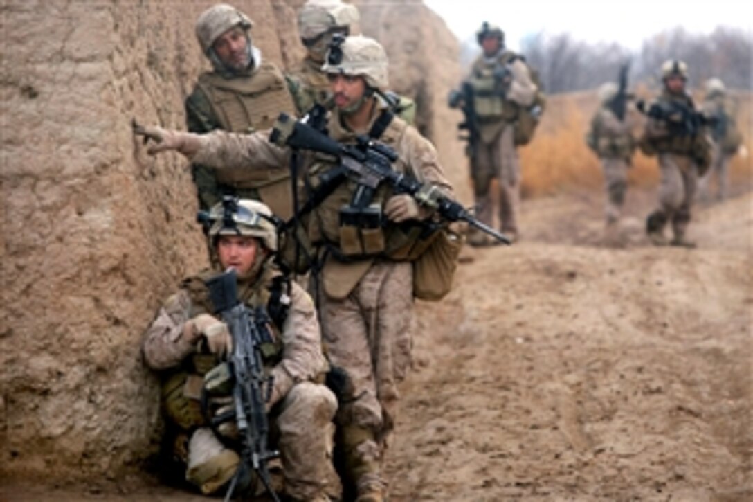 U.S. Marine Corps Lance Cpls. Daniel Garner, kneeling, and Chris Ducharme investigate a possible improvised explosive device while on a patrol in Marja, Helmand province, Afghanistan, Feb. 22, 2010. Garner and Ducharme are assigned to India Company, 3rd Battalion, 6th Marine Regiment.