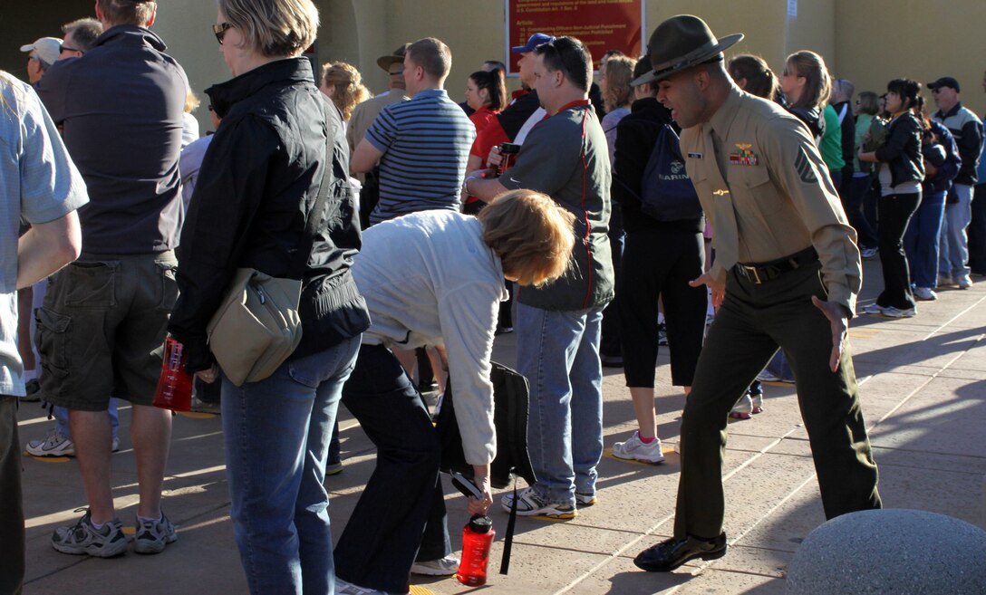 Staff Sgt. Ismael Alicea, chief drill instructor, Company A, corrects an educator as she fumbles with her personal items after being instructed to face the opposite direction while on the yellow footprints during an Educator's Workshop Feb. 23 at the Marine Corps Recruit Depot San Diego. Drill instructors give the educators a sense of urgency that receiving recruits feel when they first step foot on the depot and throughout recruit training, providing the educators with a better understanding of Marine Corps recruit training and the Corps’ mission.
