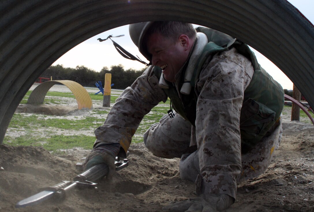 William Plant, social studies teacher, Mukwonago High School, Mukwonago, Wis., underestimates the height of his Kevlar helmet as his helmet flies off his head while finding his way through the modified Bayonet Assault Course Feb. 23 at the Marine Corps Recruit Depot San Diego. Educators are given a sense of urgency and challenge recruits feel throughout recruit training, providing the educators with a better understanding of Marine Corps recruit training and the Corps’ mission.::r::::n::