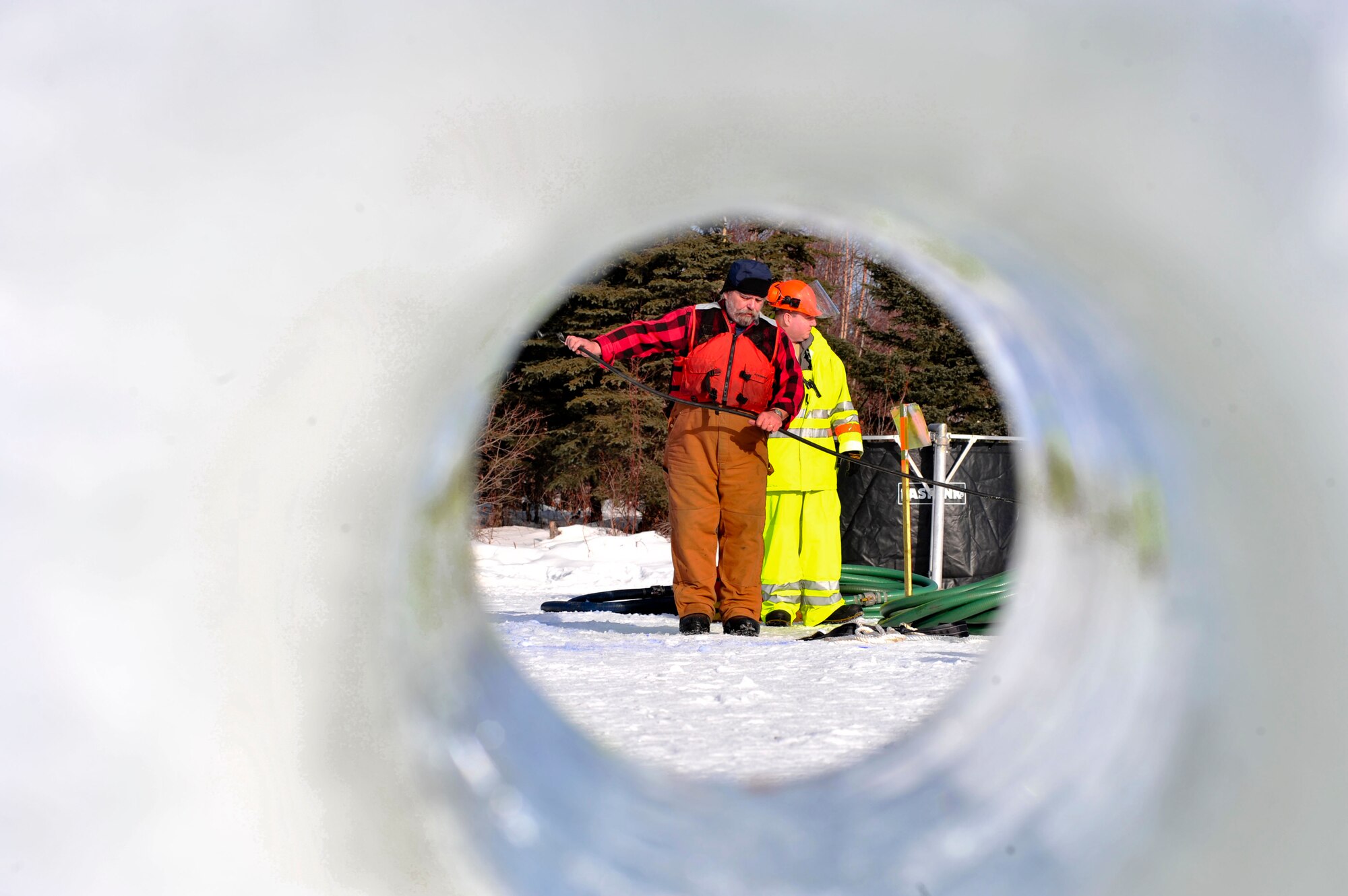 ELMENDORF AIR FORCE BASE, Alaska –Members from the 611th Civil Engineer Squadron and the Navy's Supervisor of Salvage unravel hoses during Ice Ops 2010 Feb. 24 at Elmendorf’s Sixmile Lake. During this exercise members from the 611th CES, U.S. Coast Guardsmen and Navy's Supervisor of Salvage practiced with the equipment and techniques designed for surface and under-ice spills. Technicians use this training for real-world spill response, such as the recent fuel spills at Adak Island and the spill that resulted from tug that ran aground at Bligh Reef. (Air Force photo by Airman 1st Class Christopher Gross)