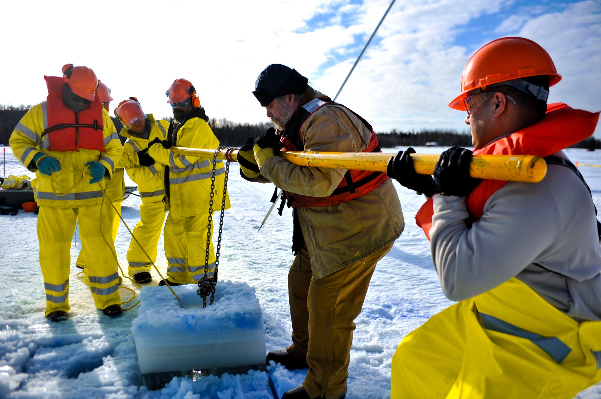 ELMENDORF AIR FORCE BASE, Alaska – Members from the 611th Civil Engineer Squadron and the Navy's Supervisor of Salvage heave out a block of ice during Ice Ops 2010 Feb. 24 at Elmendorf’s Sixmile Lake. During this exercise members from the 611th CES, U.S. Coast Guardsmen and Navy's Supervisor of Salvage practiced with the equipment and techniques designed for surface and under-ice spills. Technicians use this training for real-world spill response, such as the recent fuel spills at Adak Island and the spill that resulted from tug that ran aground at Bligh Reef. (Air Force photo by Airman 1st Class Christopher Gross)