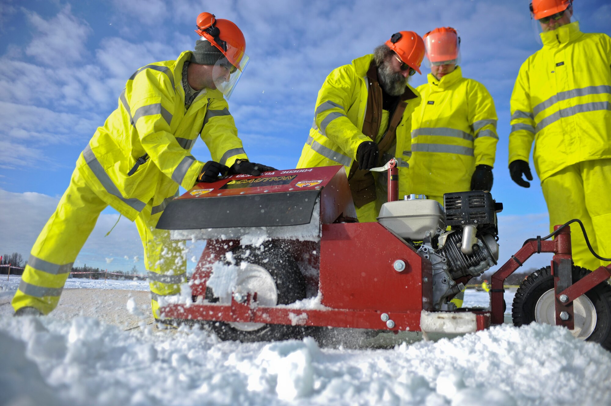 ELMENDORF AIR FORCE BASE, Alaska – Members from the 611th Civil Engineer Squadron cut through the ice during Ice Ops 2010 Feb. 24 at Elmendorf’s Sixmile Lake. During this exercise members from the 611th CES, U.S. Coast Guardsmen and Navy's Supervisor of Salvage practiced with the equipment and techniques designed for surface and under-ice spills. Technicians use this training for real-world spill response, such as the recent fuel spills at Adak Island and the spill that resulted from tug that ran aground at Bligh Reef. (Air Force photo by Airman 1st Class Christopher Gross)