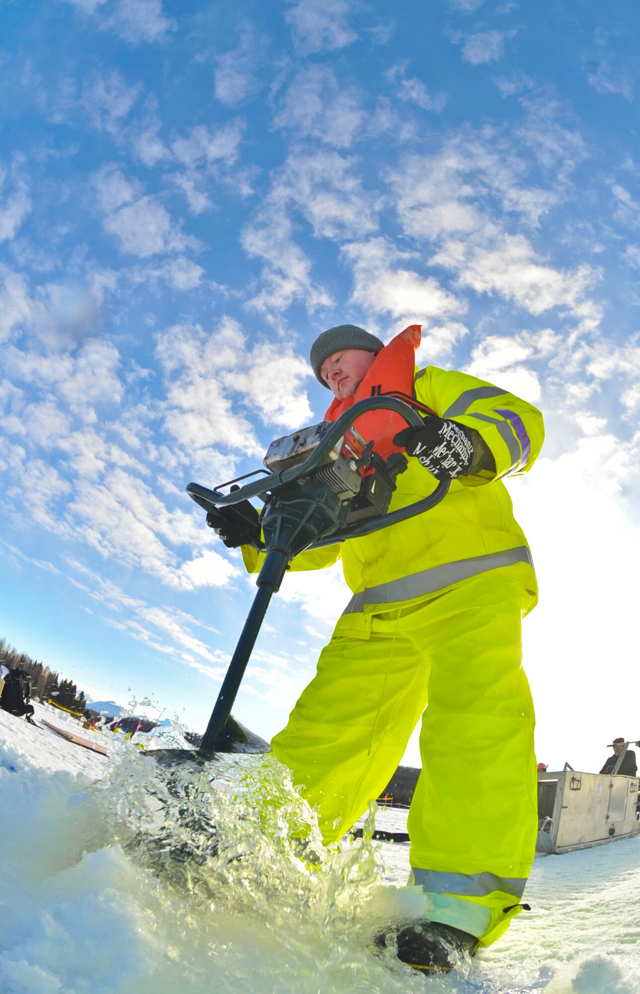 ELMENDORF AIR FORCE BASE, Alaska –Tech. Sgt. William Stewart, 611th Civil Engineer Squadron, drills through the ice with an auger so giant ice cubes can be lifted out of the water during Ice Ops 2010 Feb. 24 at Elmendorf’s Sixmile Lake. During this exercise members from the 611th CES, U.S. Coast Guardsmen and Navy's Supervisor of Salvage practiced with the equipment and techniques designed for surface and under-ice spills. Technicians use this training for real-world spill response, such as the recent fuel spills at Adak Island and the spill that resulted from a tug that ran aground at Bligh Reef. (Air Force photo by Airman 1st Class Christopher Gross) 