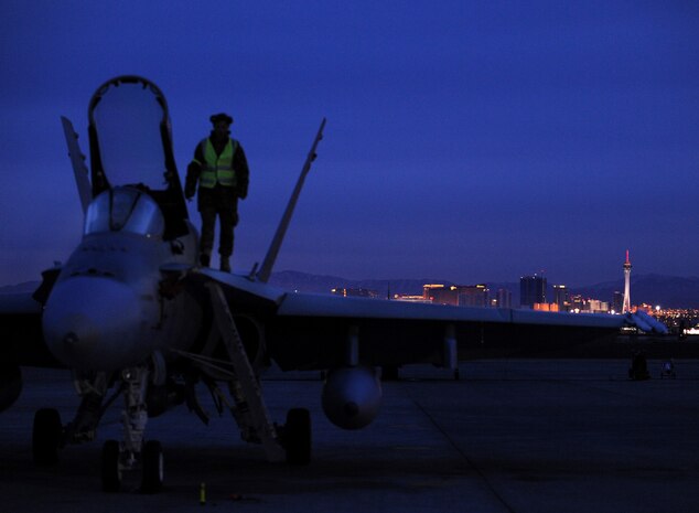 NELLIS AIR FORCE BASE, Nev. -- Corporal Jeff Dore, crew chief assigned to the 77th Fighter Squadron, Royal Australian Air Force, walks on top of a F-18 with the Las Vegas Strip in the background at Red Flag 10-3 Feb. 23, 2010.  Red Flag is a realistic combat training exercise involving the air forces of the United States and its allies. The exercise is conducted on the 15,000-square-mile Nevada Test and Training Range, north of Las Vegas. (U.S. Air Force photo by Airman 1st Class Brett Clashman/RELEASED)