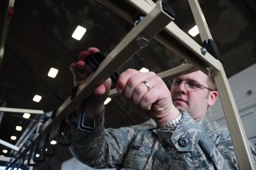 ELLSWORTH AIR FORCE BASE, S.D. -- Airman 1st Class Dave Jack, 28th Civil Engineer Squadron emergency management apprentice, constructs decontamination racks in preparation, Feb. 24, for the upcoming Phase II Operational Readiness Exercise.  The Phase II ORE will test Airmen across the base on their readiness in a deployed environment. (U.S. Air Force photo/Airman 1st Class Anthony Sanchelli)