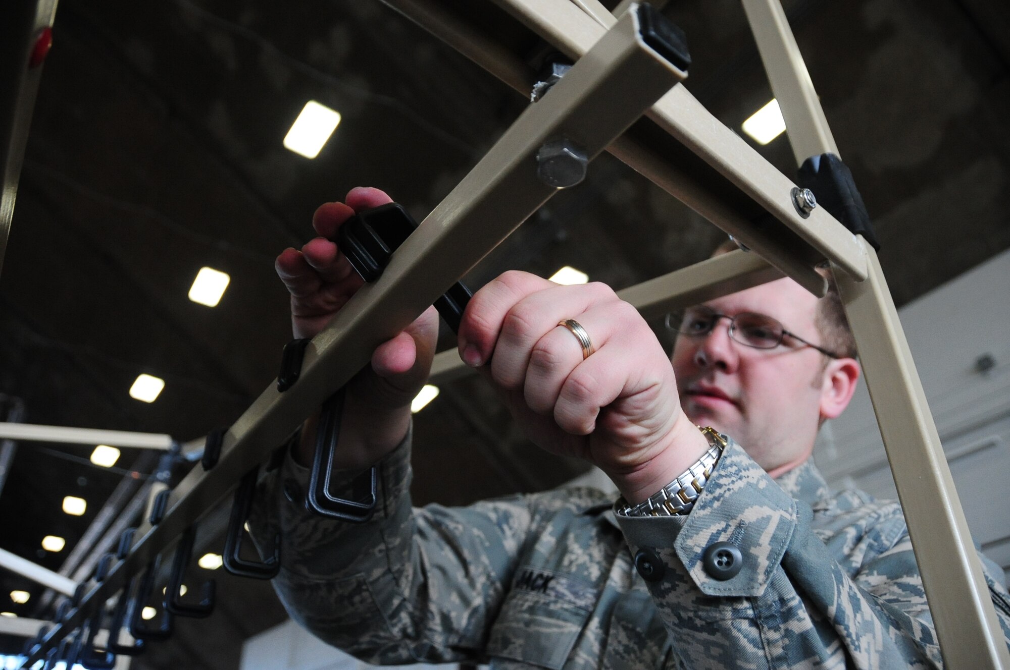 ELLSWORTH AIR FORCE BASE, S.D. -- Airman 1st Class Dave Jack, 28th Civil Engineer Squadron emergency management apprentice, constructs decontamination racks in preparation, Feb. 24, for the upcoming Phase II Operational Readiness Exercise.  The Phase II ORE will test Airmen across the base on their readiness in a deployed environment. (U.S. Air Force photo/Airman 1st Class Anthony Sanchelli)