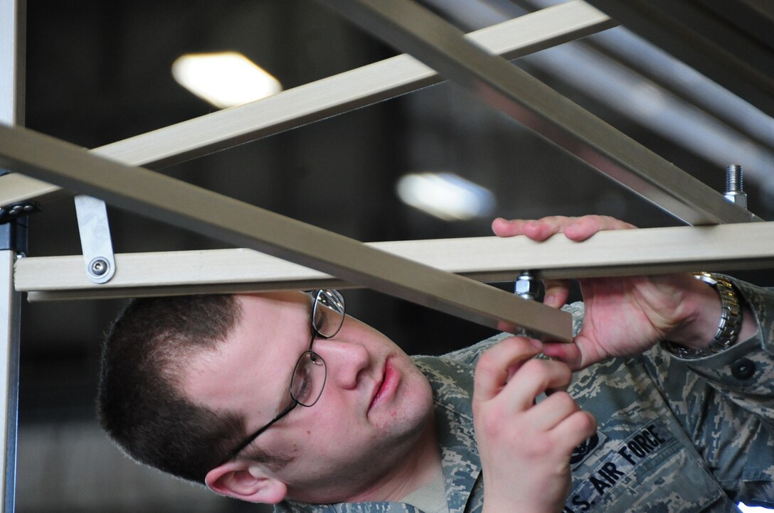 ELLSWORTH AIR FORCE BASE, S.D. -- Airman 1st Class Dave Jack, 28th Civil Engineer Squadron emergency management apprentice, constructs decontamination racks in preparation, Feb. 24, for the upcoming Phase II Operational Readiness Exercise.  The Phase II ORE will test Airmen across the base on their readiness in a deployed environment. (U.S. Air Force photo/Airman 1st Class Anthony Sanchelli)
