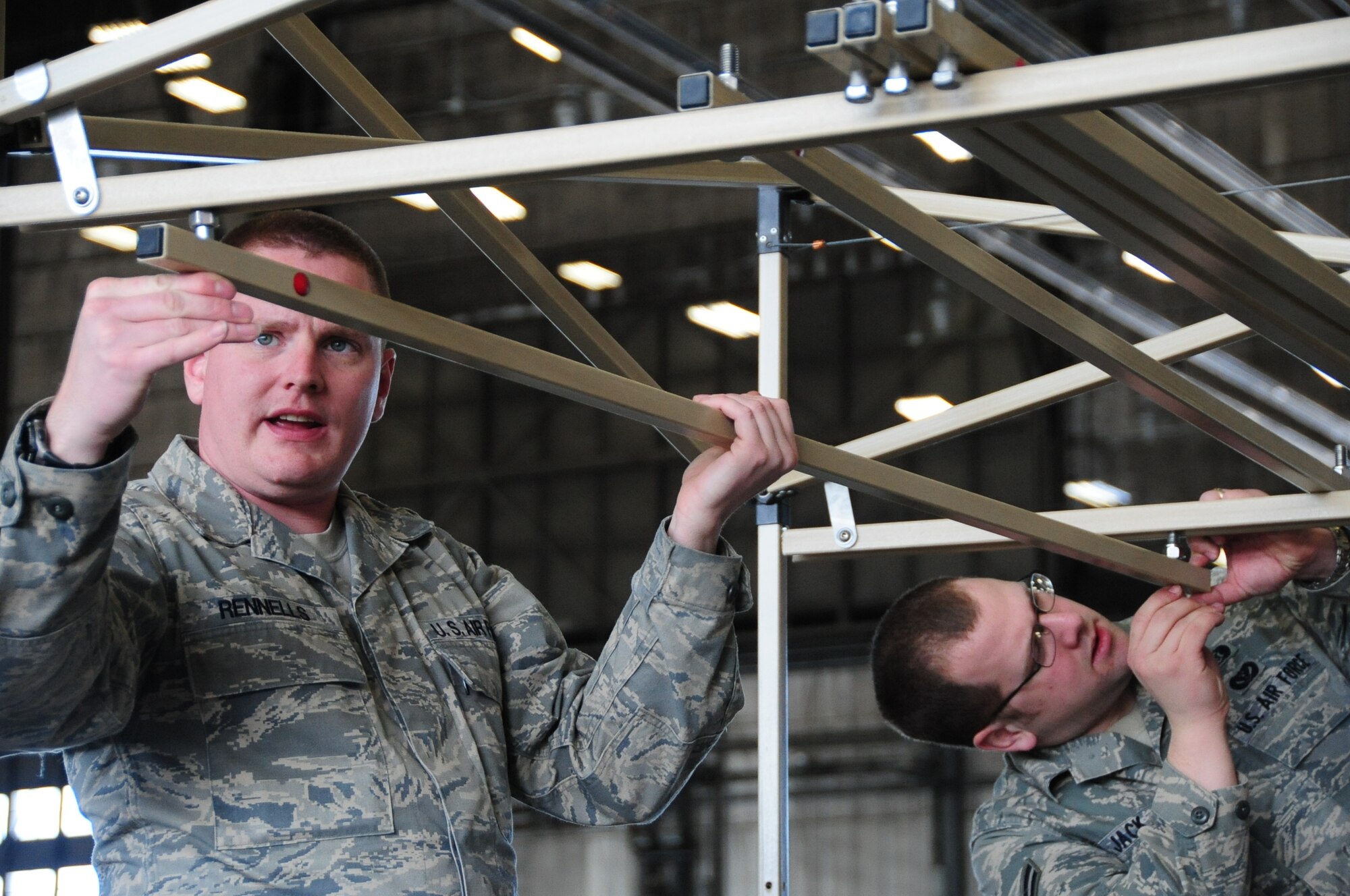 ELLSWORTH AIR FORCE BASE, S.D. -- (Left to right) Staff Sgt. Damian Rennells, 28th Logistics Readiness Squadron mobile hydrant supervisor and Airman 1st Class Dave Jack, 28th Civil Engineer Squadron emergency management apprentice, construct decontamination racks in preparation, Feb. 24, for the upcoming Phase II Operational Readiness Exercise.  The Phase II ORE will test Airmen across the base on their readiness in a deployed environment. (U.S. Air Force photo/Airman 1st Class Anthony Sanchelli)