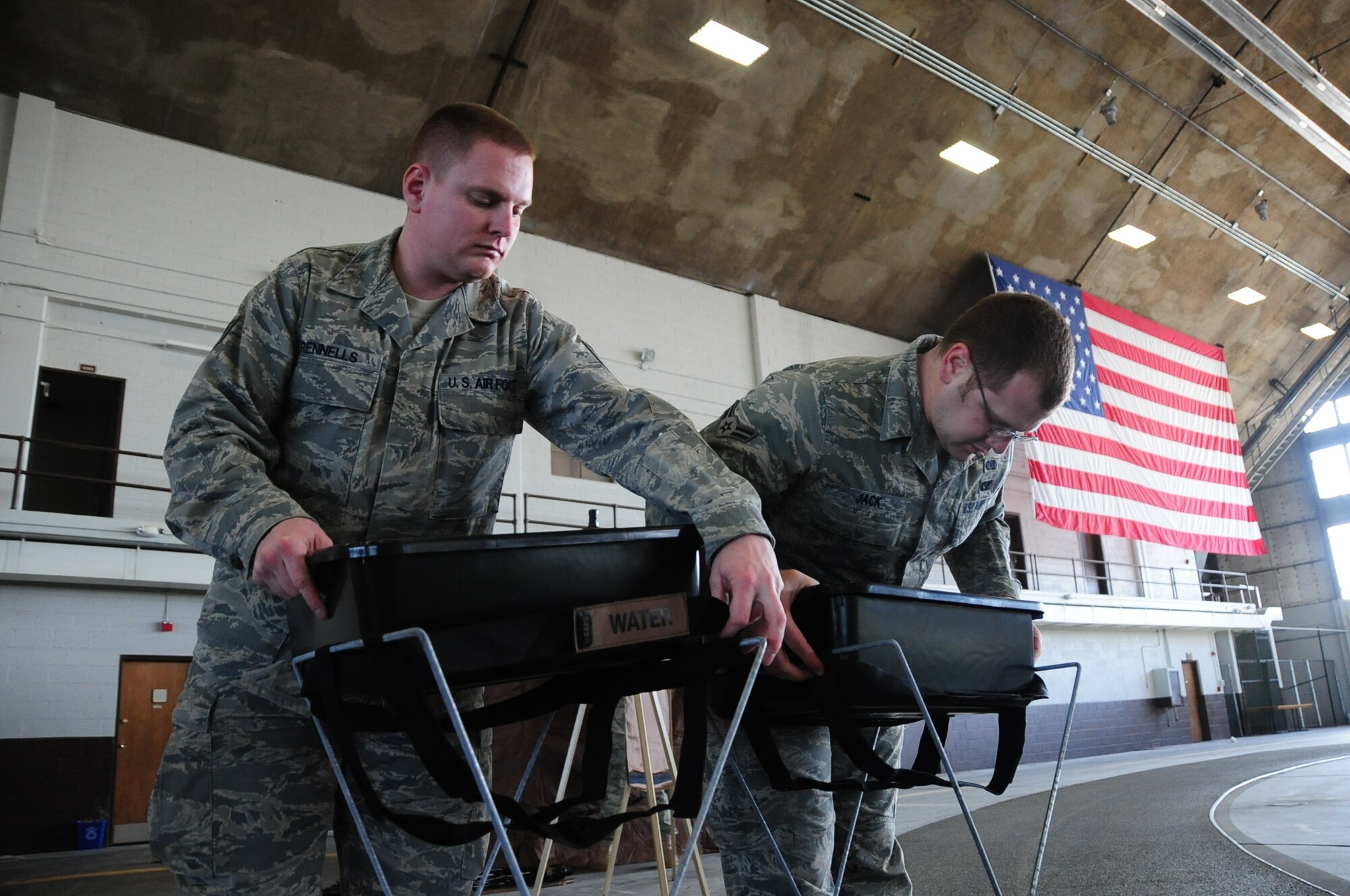 ELLSWORTH AIR FORCE BASE, S.D. -- (Left to right) Staff Sgt. Damian Rennells, 28th Logistics Readiness Squadron mobile hydrant supervisor and Airman 1st Class Dave Jack, 28th Civil Engineer Squadron emergency management apprentice, put together decontamination stations in preparation, Feb. 24, for the upcoming Phase II Operational Readiness Exercise.  The Phase II ORE will test Airmen across the base on their readiness in a deployed environment. (U.S. Air Force photo/Airman 1st Class Anthony Sanchelli)