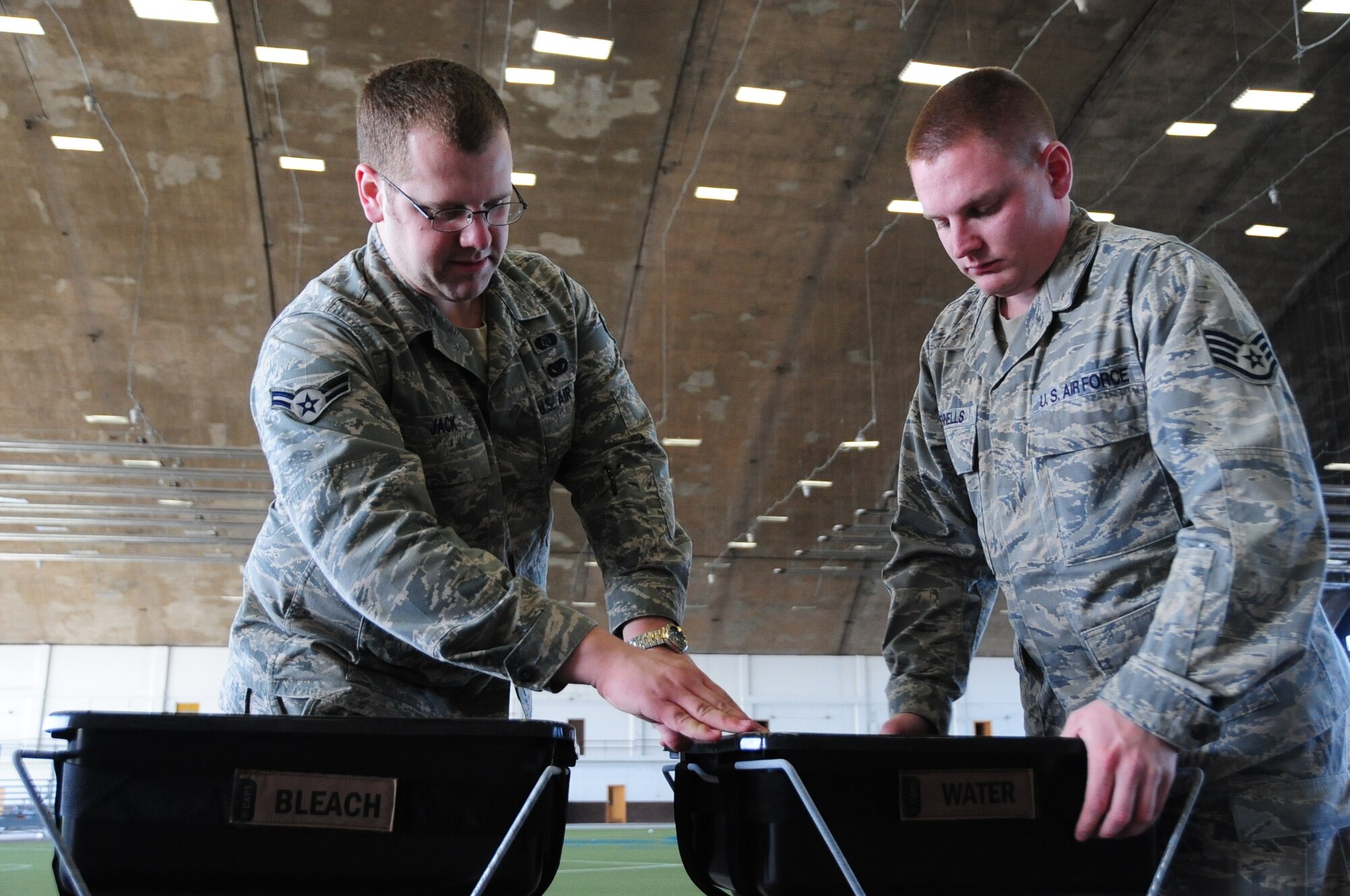 ELLSWORTH AIR FORCE BASE, S.D. -- (Left to right) Airman 1st Class Dave Jack, 28th Civil Engineer Squadron emergency management apprentice and Staff Sgt. Damian Rennells, 28th Logistics Readiness Squadron mobile hydrant supervisor, put together decontamination stations in preparation, Feb. 24, for the upcoming Phase II Operational Readiness Exercise.  The Phase II ORE will test Airmen across the base on their readiness in a deployed environment. (U.S. Air Force photo/Airman 1st Class Anthony Sanchelli)