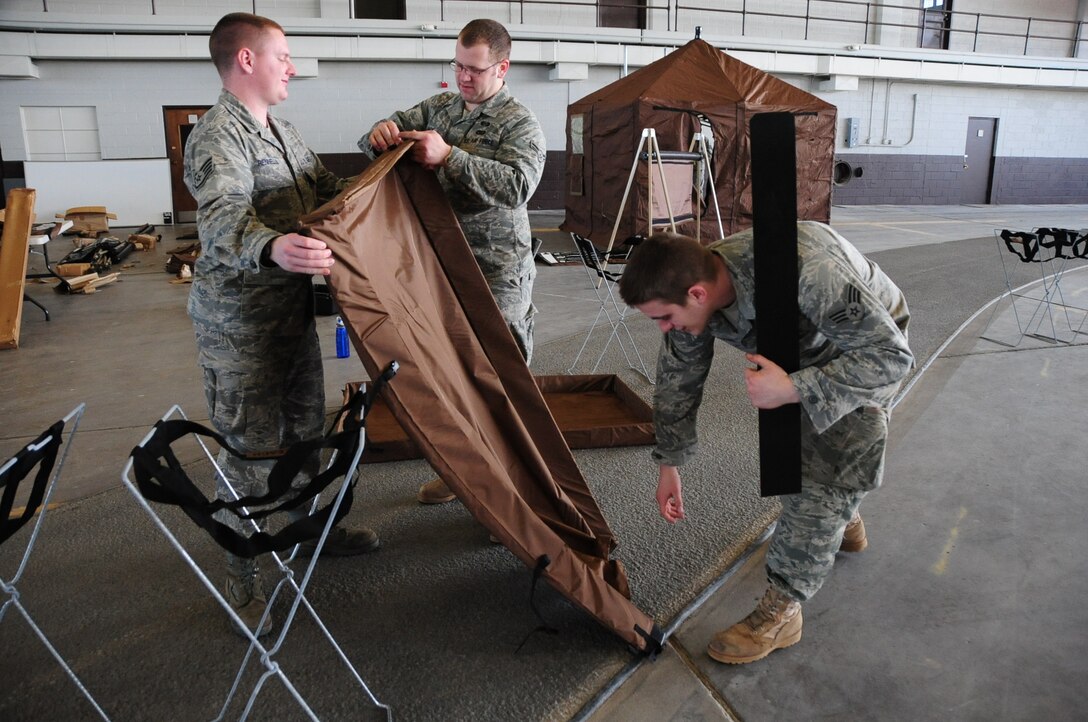 ELLSWORTH AIR FORCE BASE, S.D. -- (Left to right) Staff Sgt. Damian Rennells, 28th Logistics Readiness Squadron mobile hydrant supervisor, Airman 1st Class Dave Jack and Senior Airman Kyle Lefevere, 28th Civil Engineer Squadron emergency management members, put together decontamination stations in preparation, Feb. 24, for the upcoming Phase II Operational Readiness Exercise.  The Phase II ORE will test Airmen across the base on their readiness in a deployed environment. (U.S. Air Force photo/Airman 1st Class Anthony Sanchelli)