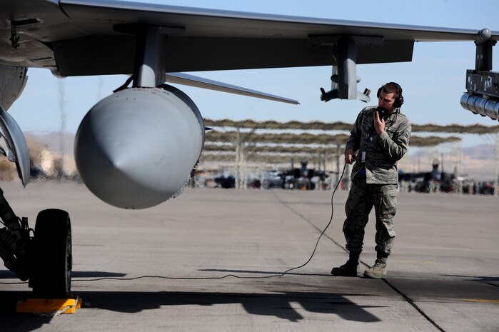 NELLIS AIR FORCE BASE, Nev. -- Airman 1st Class Joshua Koch 20th Aircraft Maintenance Squadron, crew chief from Shaw AFB, S.C. completes pre-flight checks while communicating with the pilot of his F-16 before a training mission at Red Flag 10-3 Feb. 23, 2010.  Red Flag is a realistic combat training exercise involving the air forces of the United States and its allies. The exercise is conducted on the 15,000-square-mile Nevada Test and Training Range, north of Las Vegas. (U.S. Air Force photo by Tech. Sgt. Michael R. Holzworth/RELEASED)