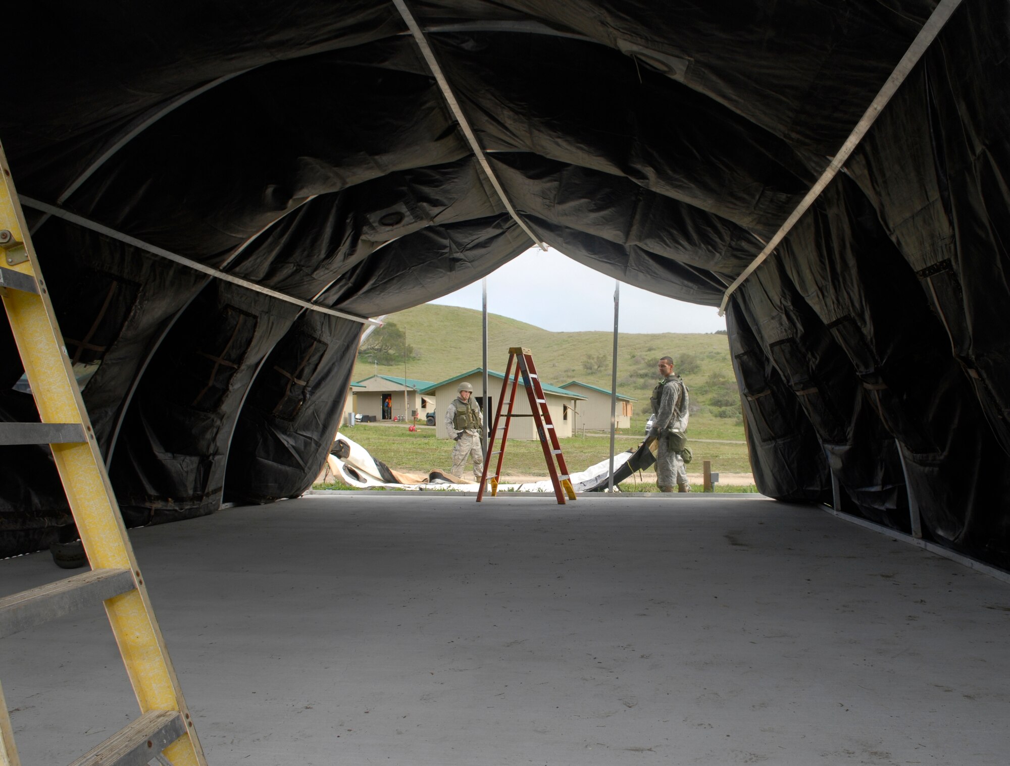 VANDENBERG AIR FORCE BASE, Calif. -- Dragging the door into place, Senior Airman Roberto Chavez and Airman 1st Class Robert Leming set up a medical tent at the North Star exercise site here Thursday, Feb. 18, 2010. Both Airmen, with the 30th Civil Engineer Squadron, set up the only tent used at North Star. (U.S. Air Force photo / Senior Airman Ashley Reed)