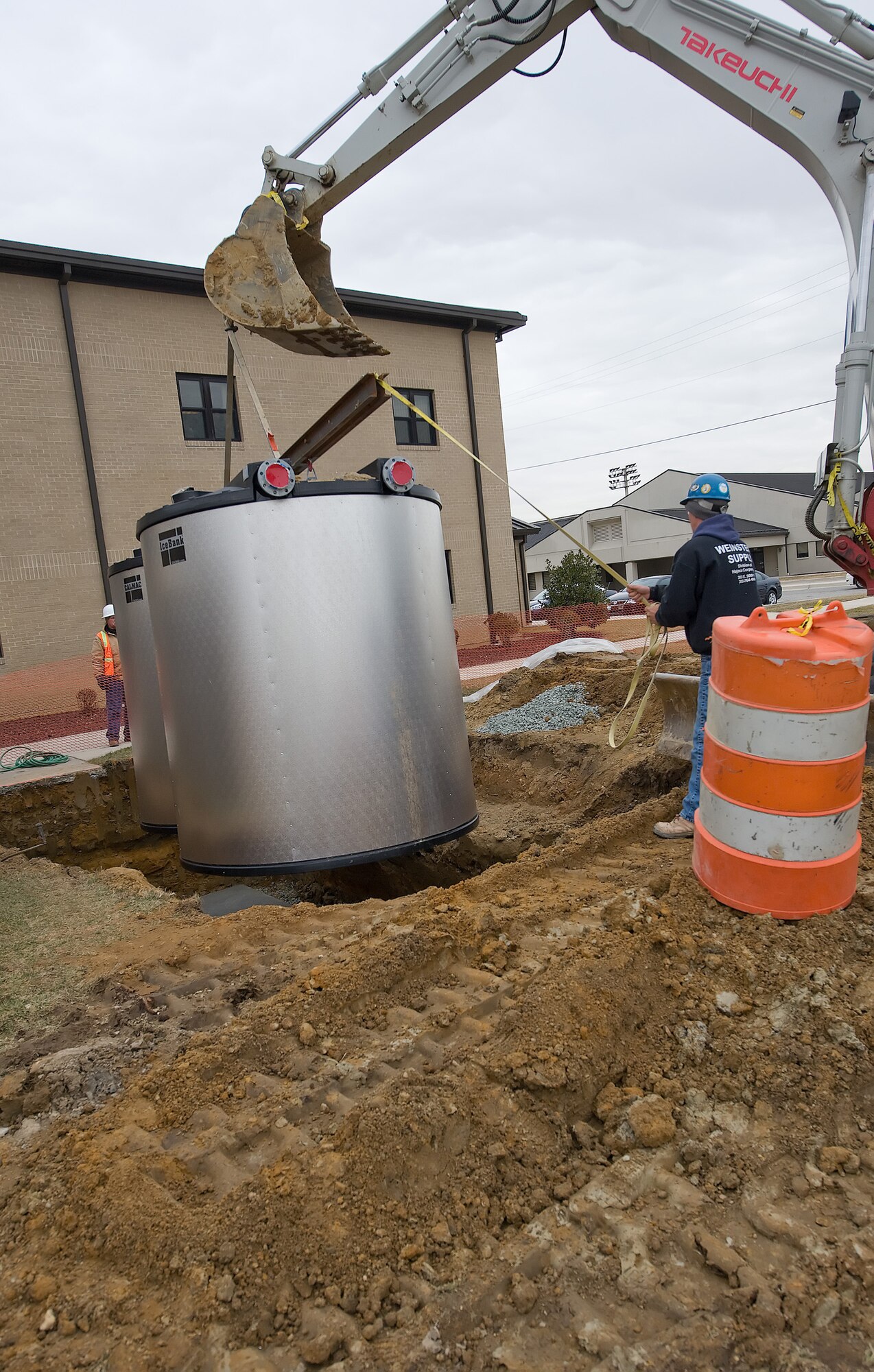 A set of ice storage tanks being lowered onto a foundation during their installation. The tanks are located at many facilities on Dover Air Force Base, and are part of the installations energy reduction mandate, helping to reduce overall costs of cooling facilities during the summer months. (U.S. Air Force photo/Brianne Zimny)