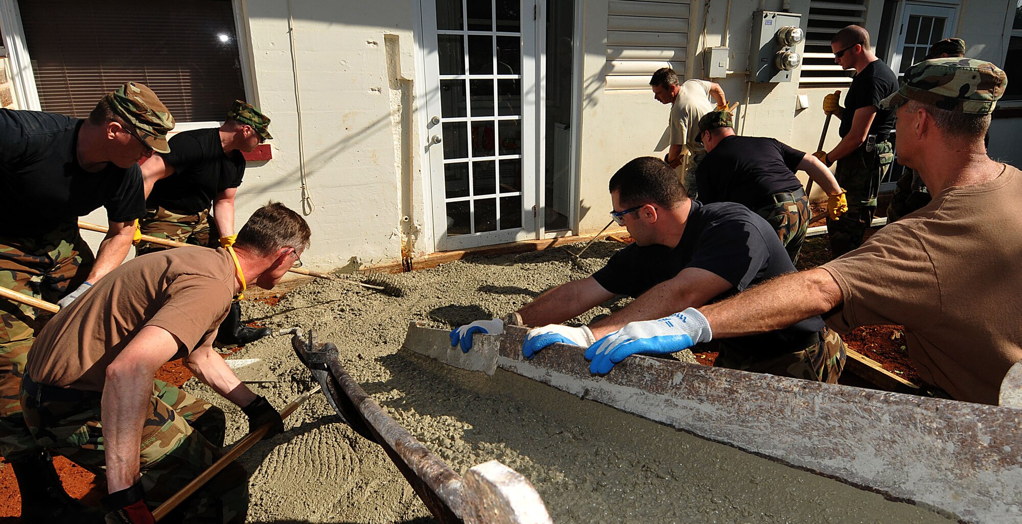 COAST GUARD AIR STATION BORINQUEN, Puerto Rico --  Members of the 176th Wing's Civil Engineer Squadron pour concrete for a patio here Feb. 11, 2010. A group of 45 squadron members spent two weeks here in early February to train and sharpen their skills on a wide range of infrastructure projects, upgrades and renovations. The squadron undertakes such a mission --  called a Deployment for Training, or DFT -- every year or two. Recent DFTs have taken the squadron's men and women to Israel, Southern California, Hawaii, Ecuador, Okinawa, Minnesota and Texas. AKANG photo by 1st. Lt. John Callahan. 